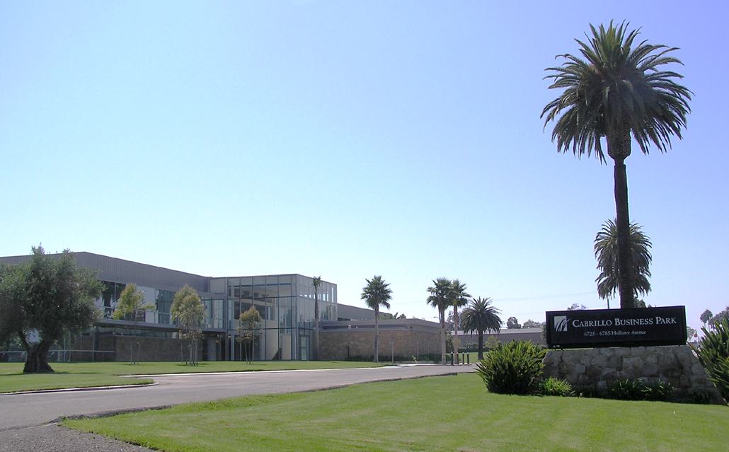 A suburban office park provides a sprawling, campus-like environment with multiple low-rise buildings and abundant surface parking.
