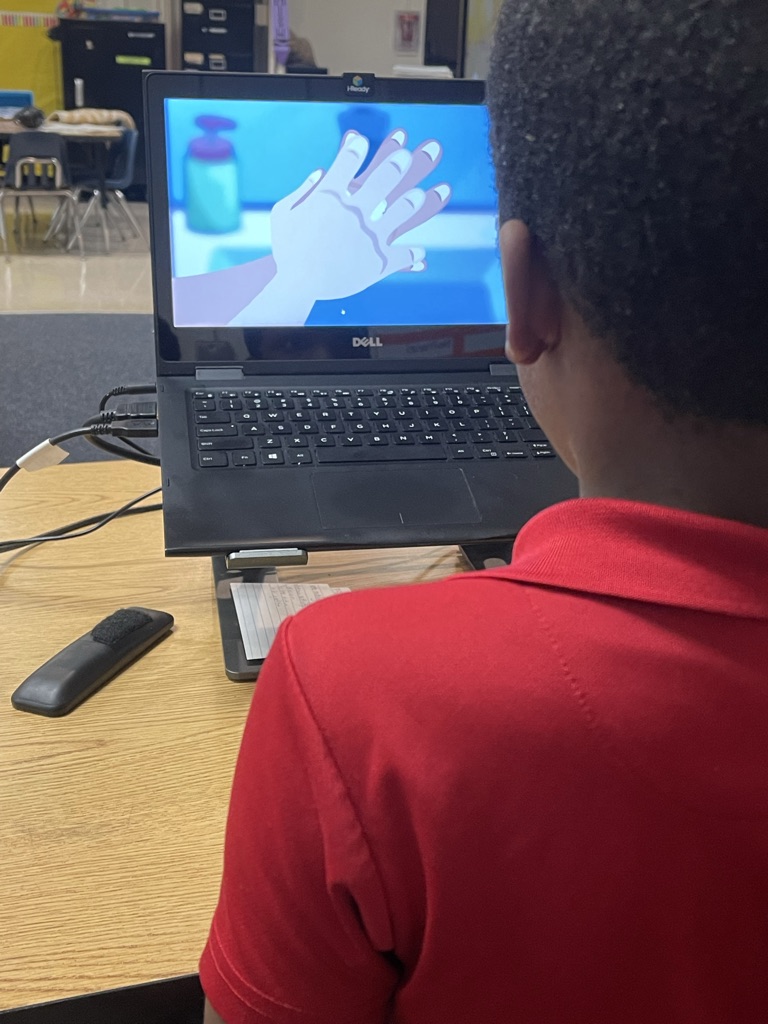 A student learning handwashing through video modeling. This technique allows students to repeatedly observe and analyze the exact behavioral chains required for functional life skills before practicing them physically.
