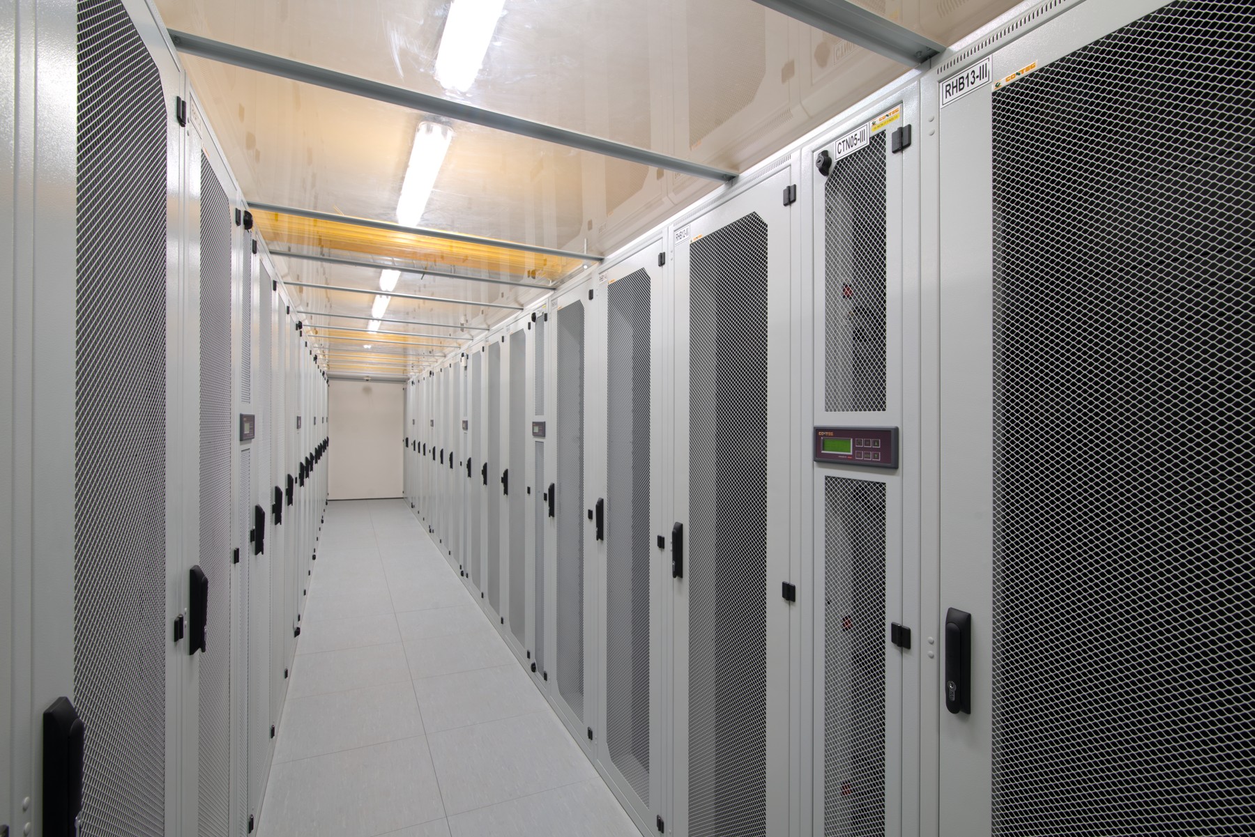 A server room containing racks of critical IT infrastructure. The foundation of cybersecurity relies on ensuring these physical environments remain utterly inaccessible to unauthorized personnel.