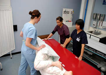 A slide board acts as a stable geometric bridge, allowing patients with upper body strength to perform a seated transfer between surfaces without bearing weight on their legs.