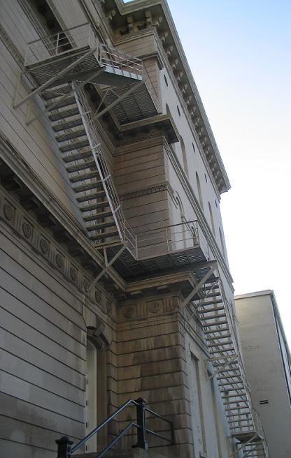 Building and fire codes, such as those mandating external fire escapes, are enforced under the government's police power to ensure minimum safety standards for occupancy.