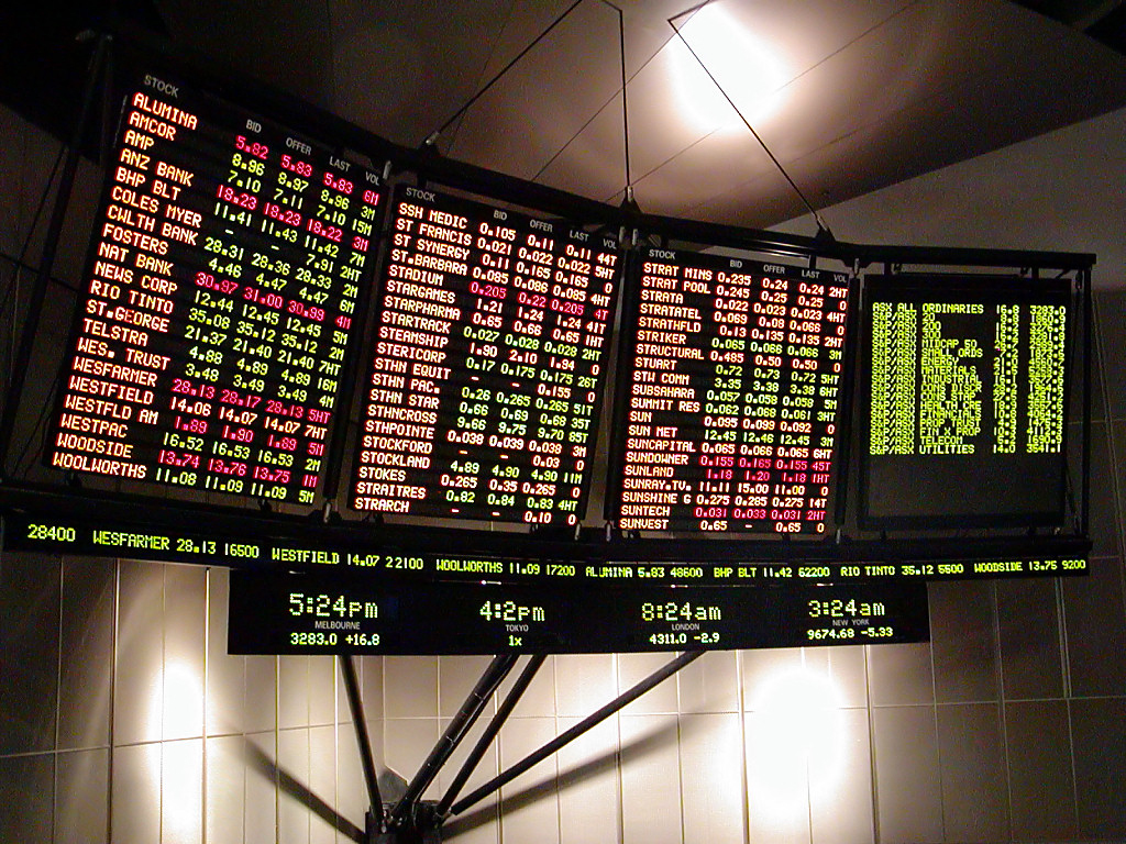 Modern digital tickers display real-time market pricing. When a firm acts as a dealer in a principal capacity, it profits from the spread between the market bid and ask prices rather than charging an agency commission.