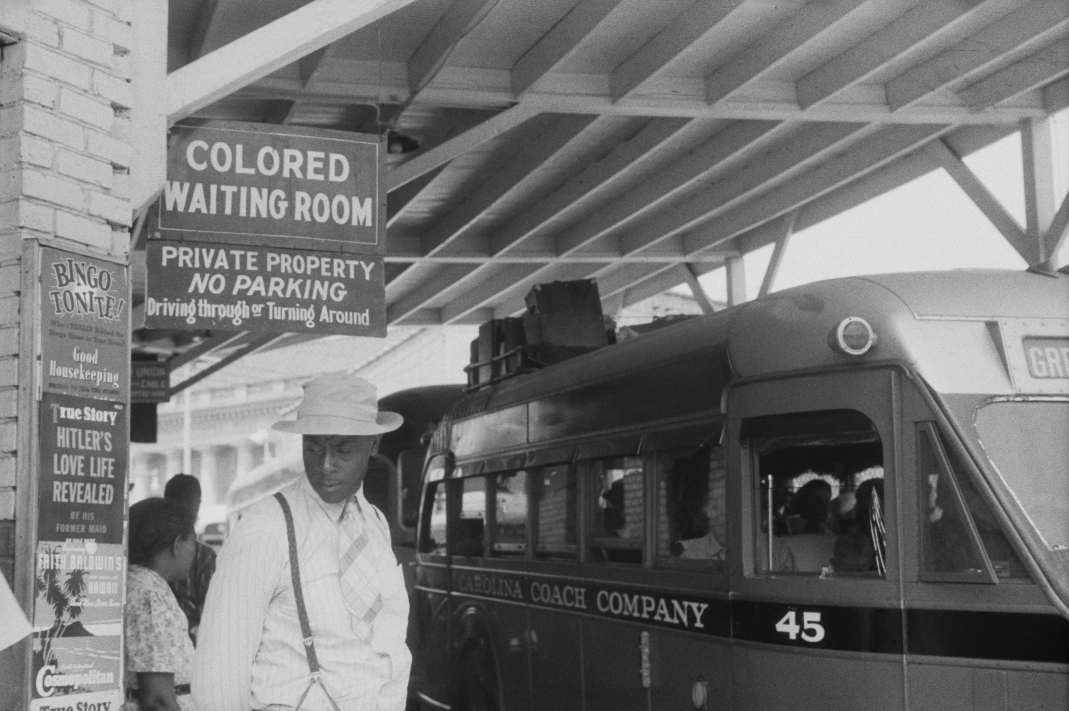 A 1940 photograph of a segregated bus station in North Carolina, illustrating the stark realities of the Jim Crow South explored in Mildred D. Taylor's works.