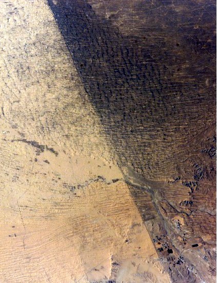 A satellite view of the Israel-Egypt border demonstrating the impact of land use: the lighter, degraded landscape on the Egyptian side is the direct result of chronic overgrazing.