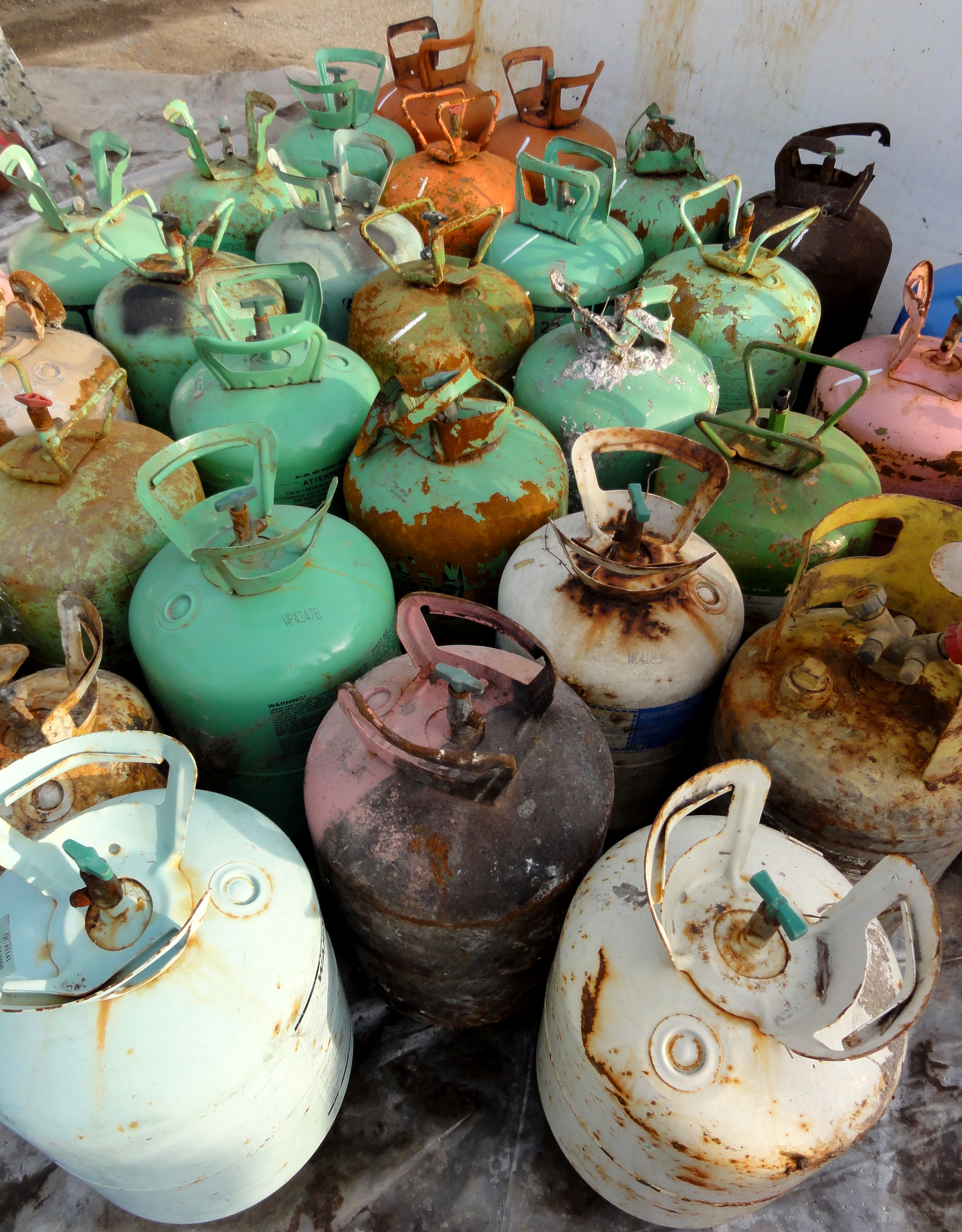 Recovered refrigerant cylinders awaiting proper reclamation. Federal law strictly prohibits the intentional venting of CFCs and mandates rigorous recycling protocols during HVAC servicing.