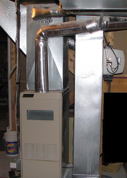 A modern forced-air gas furnace. These systems rely on a motorized blower fan to distribute heated air through a network of supply and return ducts.
