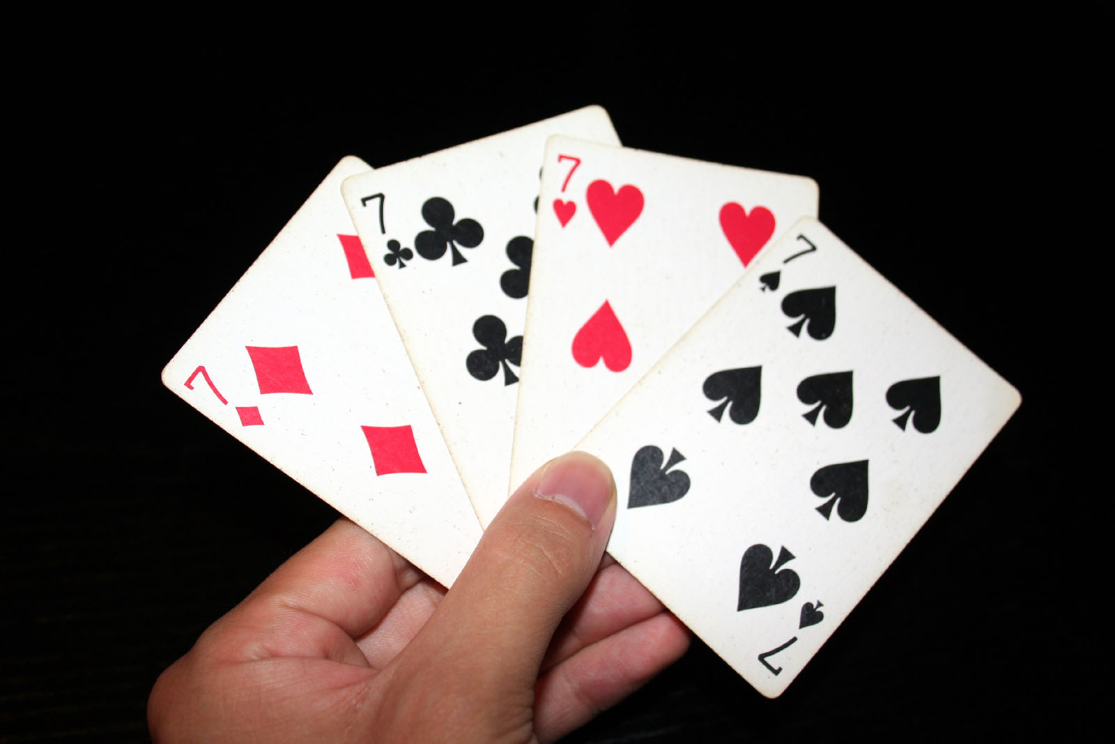 The four standard playing card suits: diamonds, clubs, hearts, and spades. Each suit contains 13 cards, creating a uniform sample space of 52 distinct outcomes.