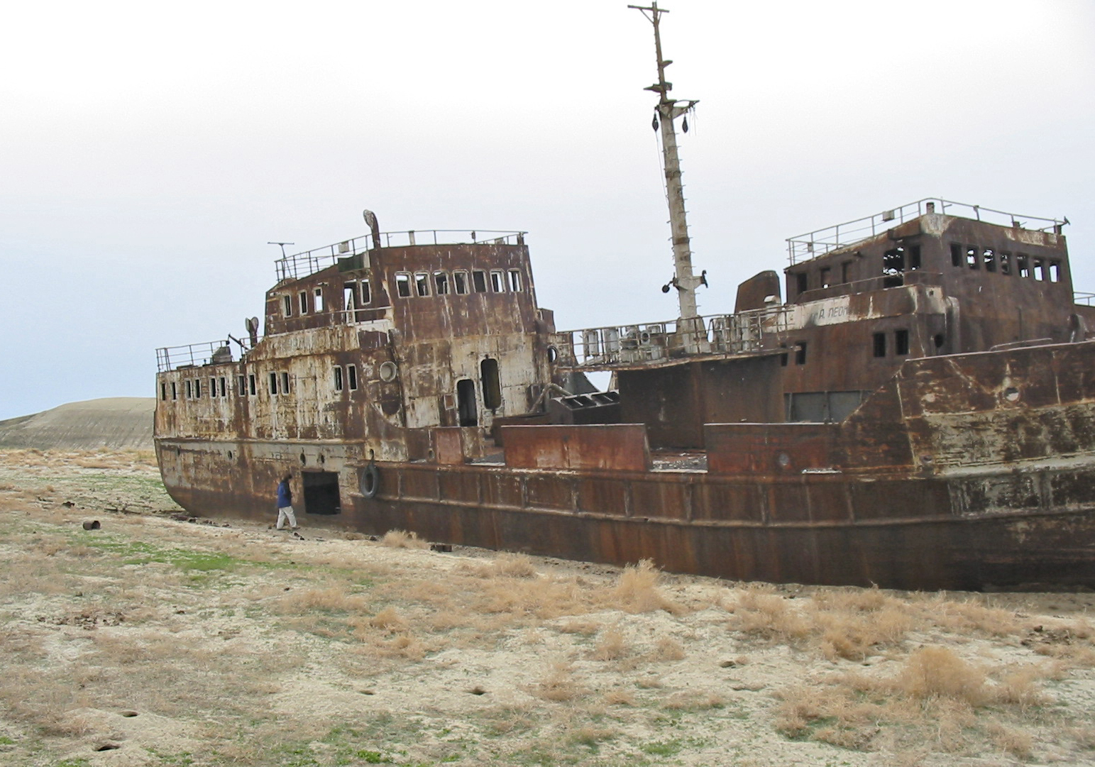 An abandoned ship rests on the dry seabed of the former Aral Sea, a stark visual consequence of diverting its feeding rivers for massive agricultural irrigation projects.