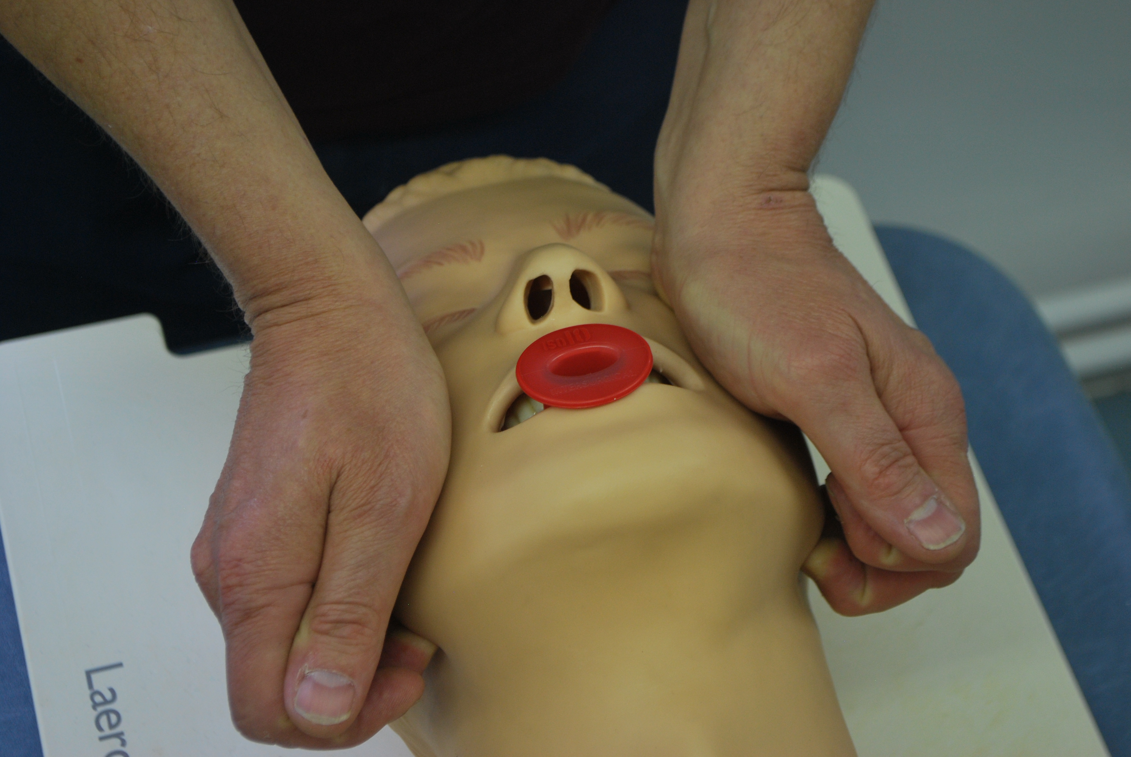 The jaw-thrust maneuver is a physical intervention used to quickly open a patient's airway during oxygen desaturation emergencies without manipulating the cervical spine.