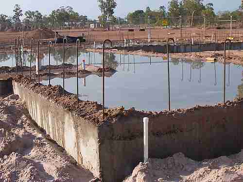 Concrete must cure before framing can begin. In project scheduling, this necessary waiting period—where no active labor occurs—is mathematically represented as a lag.