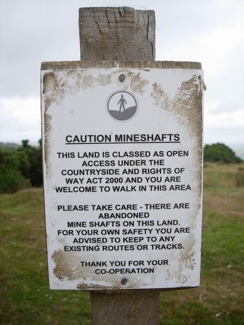 A Countryside and Rights of Way Act sign on open access land, warning of natural hazards — illustrating the section 1(6A) exclusion for risks arising from natural features of the landscape.