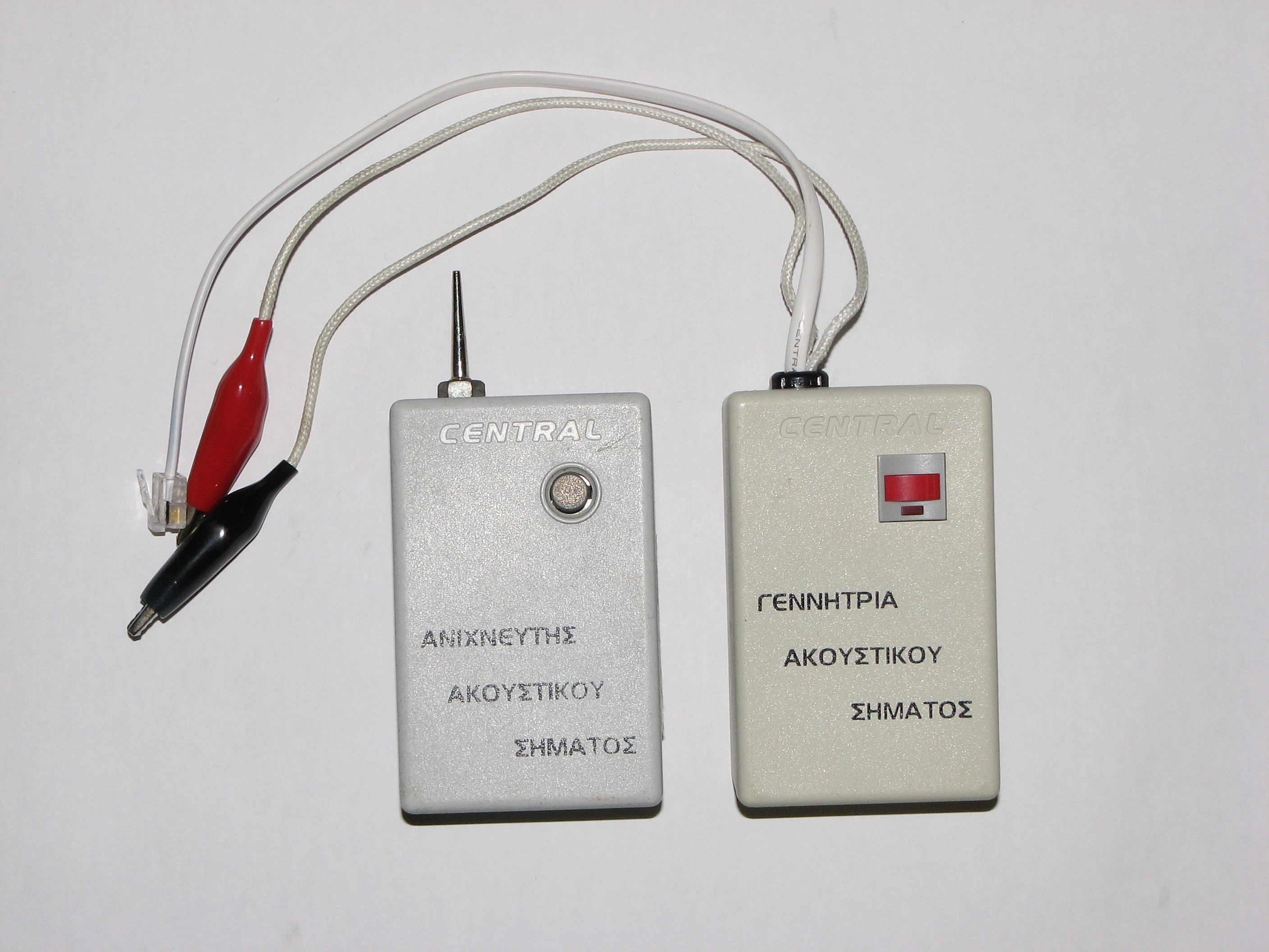 A tone generator (left) and an inductive tone probe (right) are used in tandem by technicians to trace and identify a specific wire pair within a dense, undocumented cable bundle.