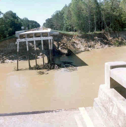A collapsed bridge resulting from flood-induced erosion illustrates the consequences of failing to account for physical constraints and environmental risks.