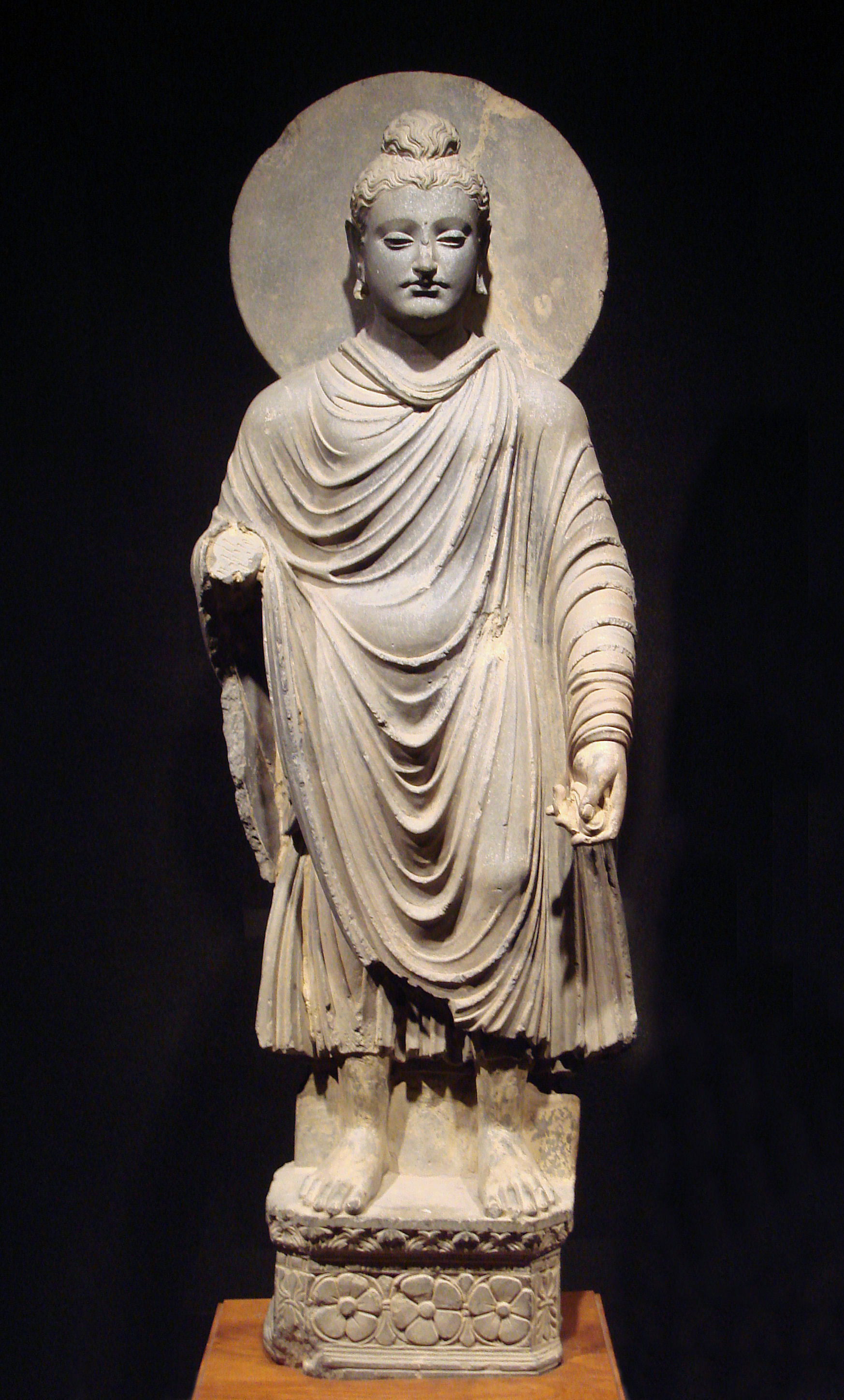 A statue of the Buddha sculpted in the Greco-Buddhist style from Gandhara, perfectly illustrating the cultural syncretism of the Hellenistic period initiated by Alexander's conquests.