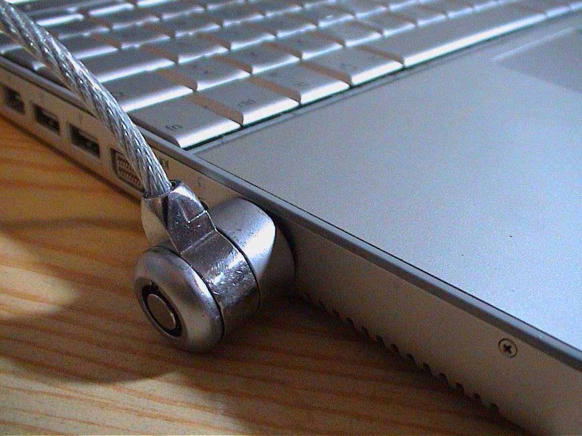 A cable lock attached to a laptop, securely anchoring the portable device to an immobile fixture to deter rapid physical theft.