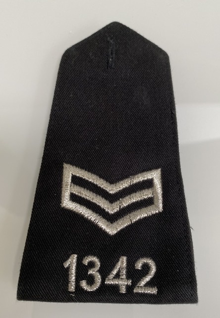 A UK police sergeant's epaulette insignia — the minimum rank an officer must hold to act as custody officer under section 37 PACE 1984.