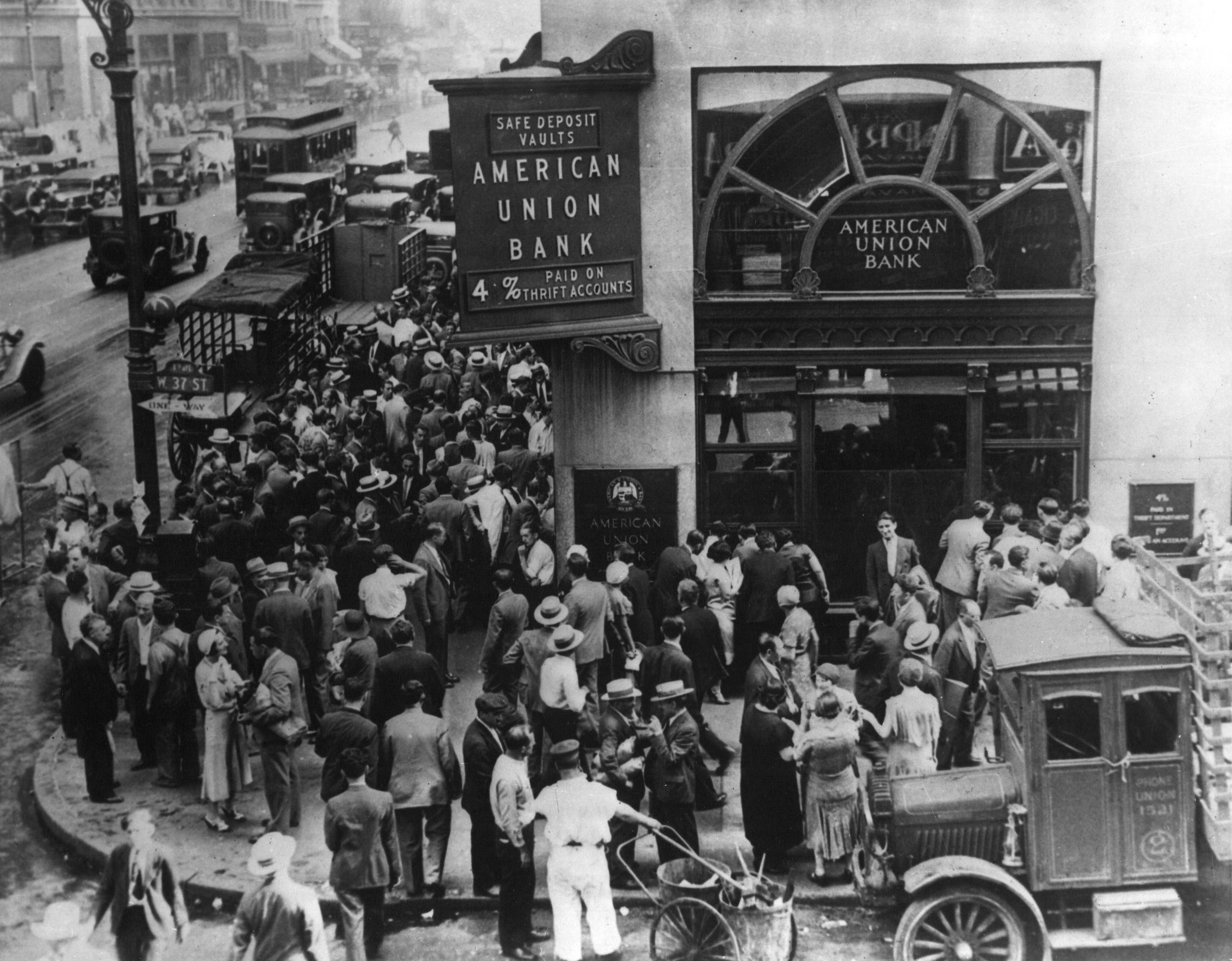A massive crowd of anxious depositors outside New York's American Union Bank. Because of fractional-reserve banking, institutions could not cover these simultaneous withdrawals, causing thousands of banks to collapse.