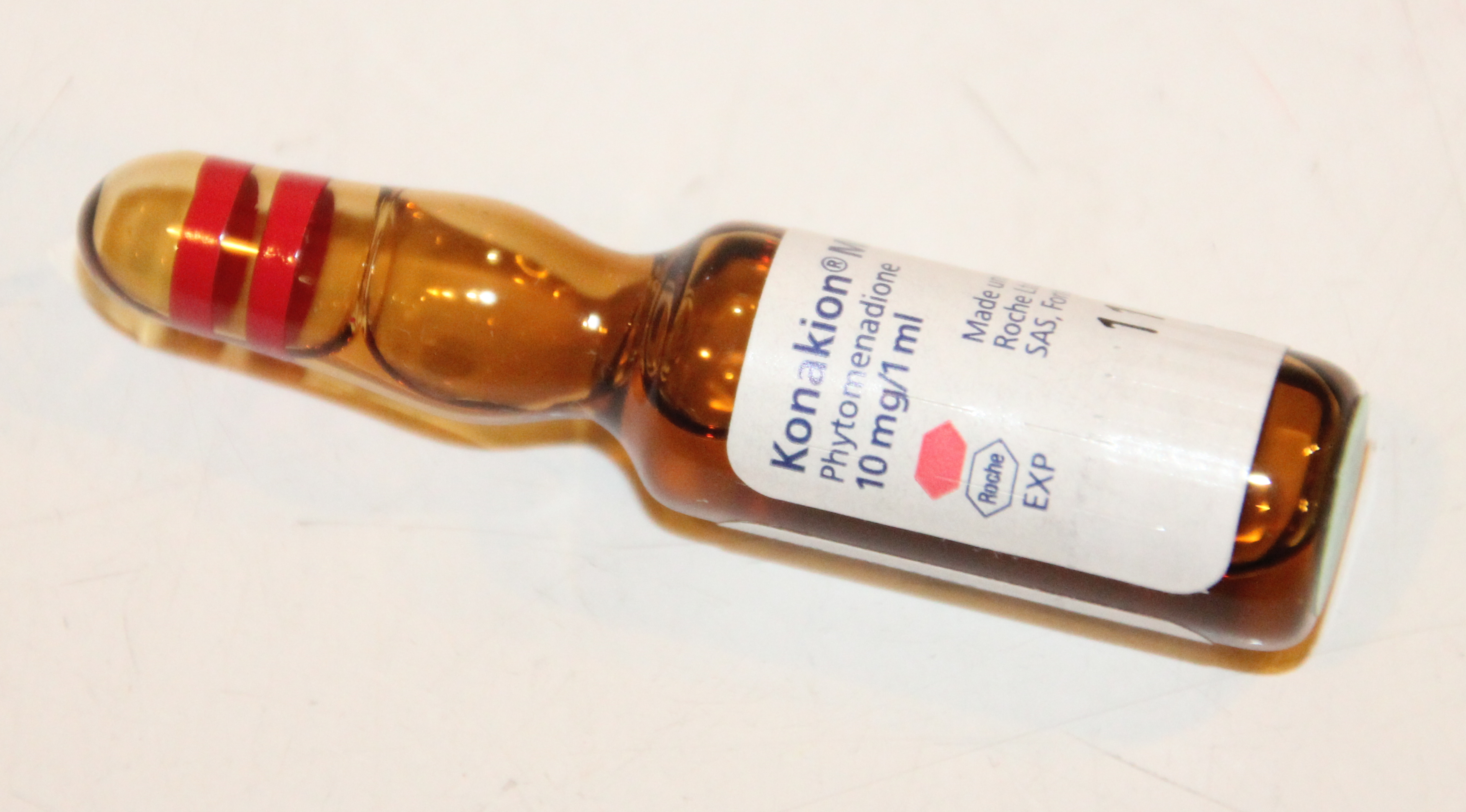 Phytomenadione (Vitamin K1) is administered via intramuscular injection to compensate for the newborn's sterile gut and prevent hemorrhagic disease.