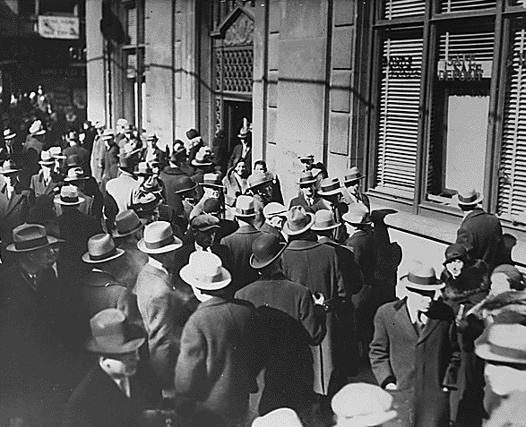 A 1933 bank run in Michigan. Sudden banking panics serve as severe negative demand shocks, causing widespread fear that abruptly curtails consumer spending and collapses aggregate demand.