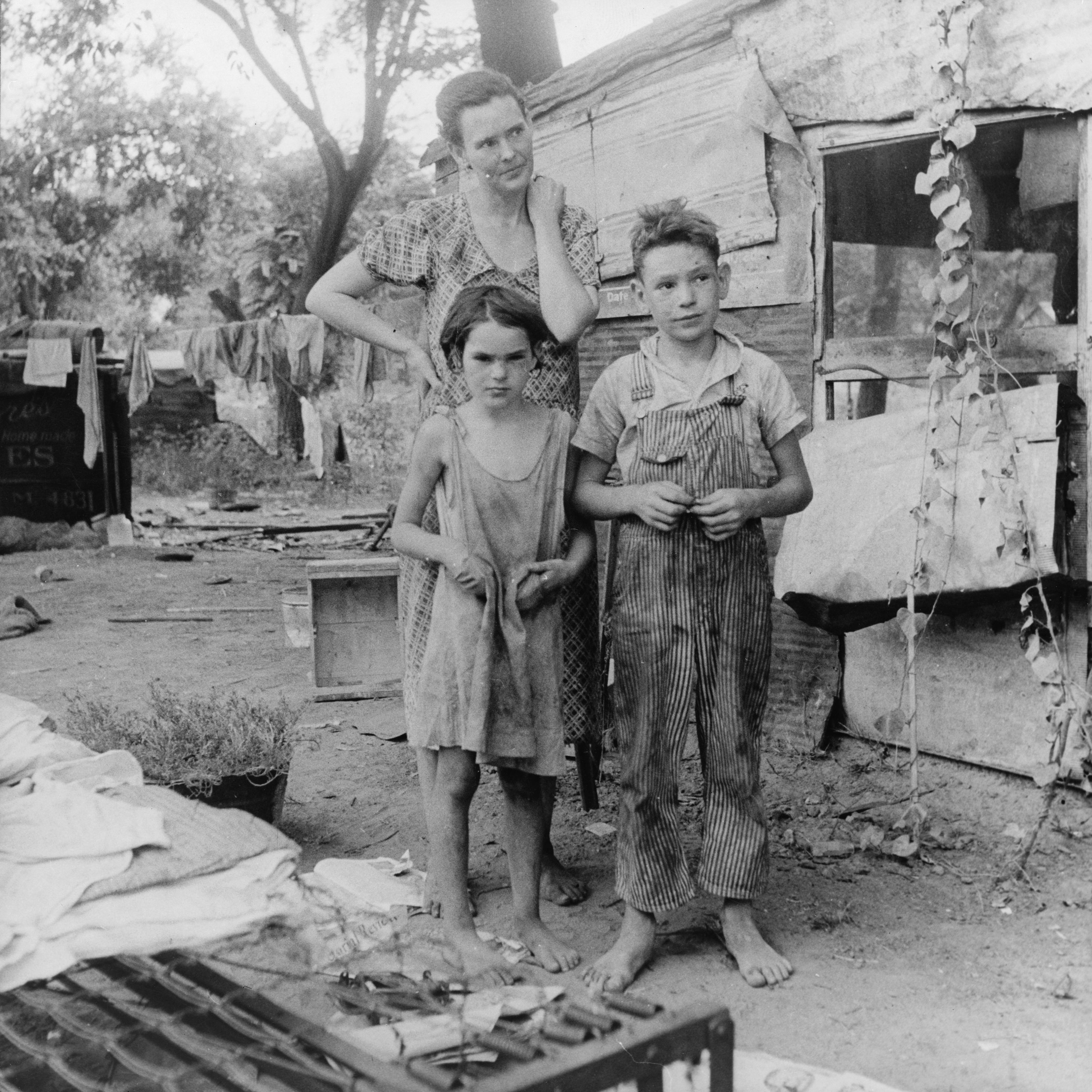 Dorothea Lange's 1936 photograph of an impoverished family captures the extreme economic hardships of the Great Depression, the central context for The Grapes of Wrath.