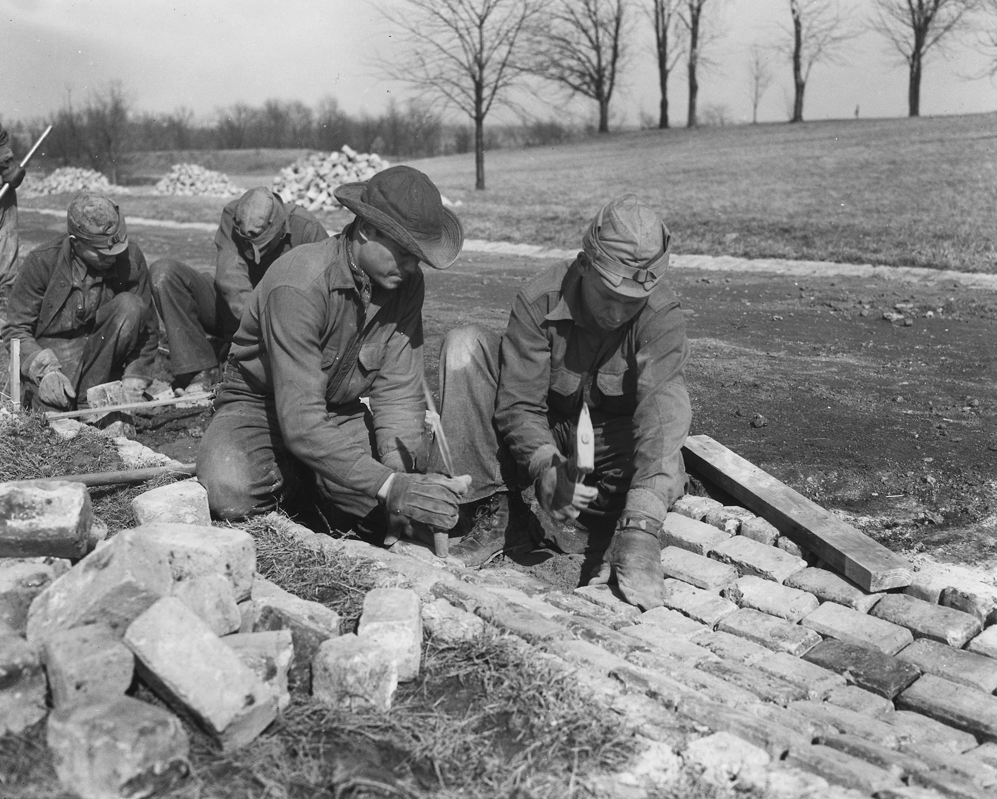 Civilian Conservation Corps (CCC) workers constructing infrastructure in 1933. Highlighting specific manual-labor projects helps students understand how the government directly intervened to lower unemployment.