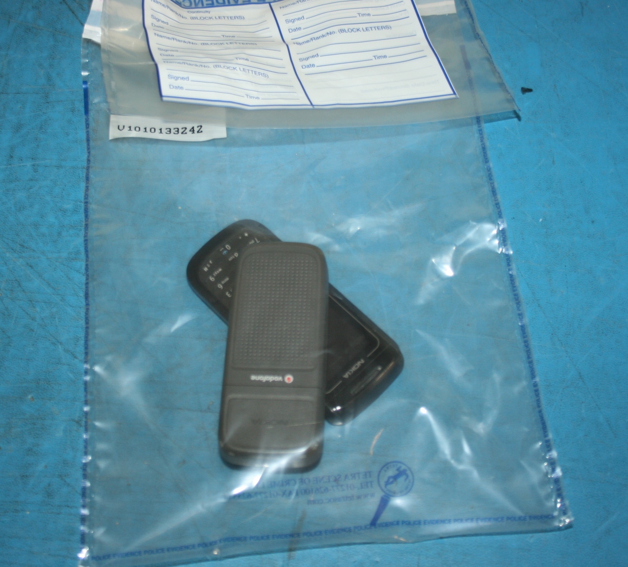 Seized mobile devices secured inside physical, tamper-evident evidence bags, a critical control for enforcing a defensible chain of custody.