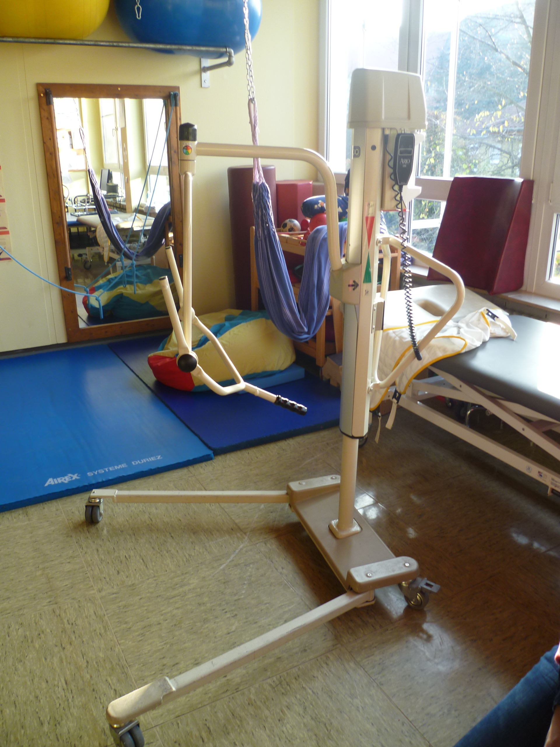 A mechanical patient lift. Nurses must always verify the machine's maximum weight capacity and rigorously inspect the fabric sling for any tears prior to initiating a transfer.