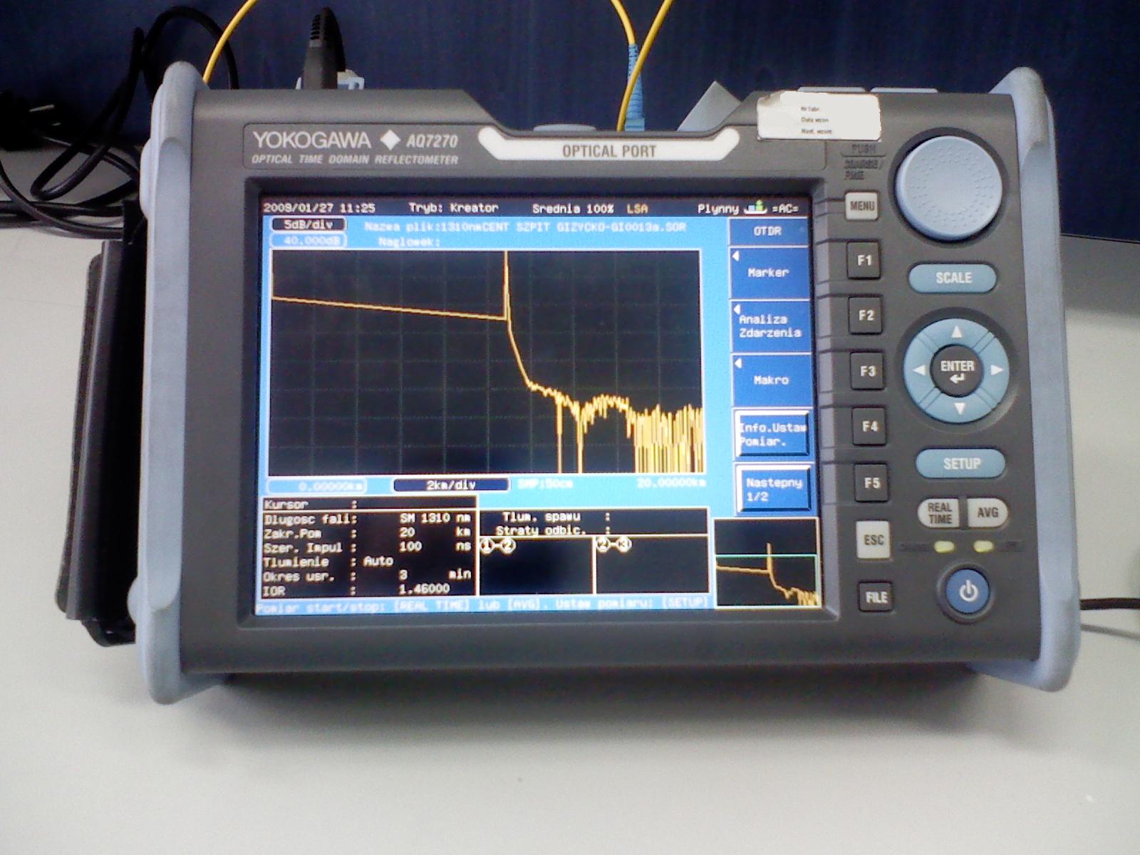 An Optical Time Domain Reflectometer (OTDR) analyzing a fiber optic circuit. The graph displays backscatter levels to visually map out optical signal attenuation, poorly fused splices, and physical breakages.
