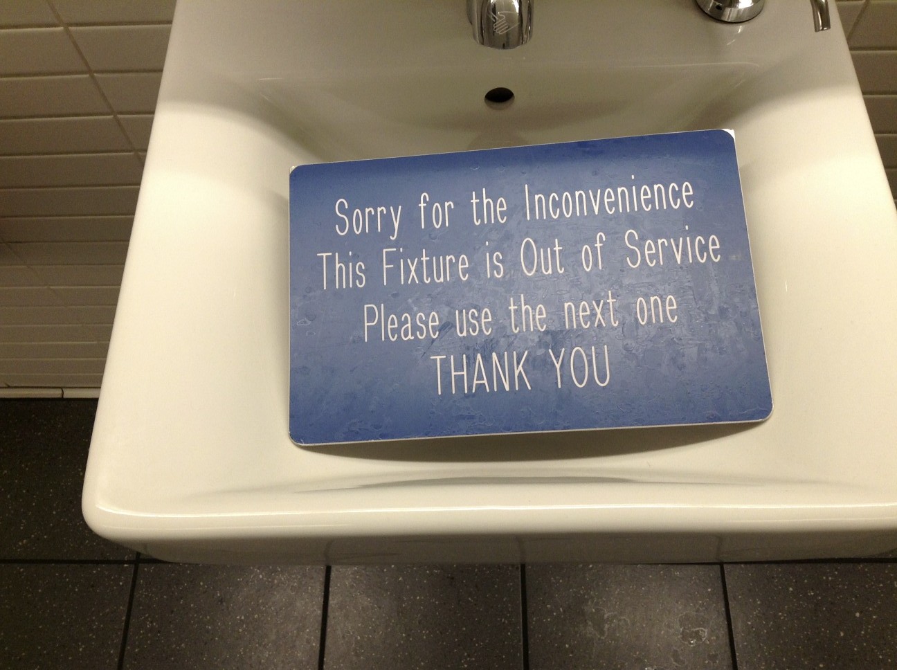 A bathroom sink fixture: because it is securely attached to the building, it counts as part of the land and passes automatically to a buyer, unlike a chattel.