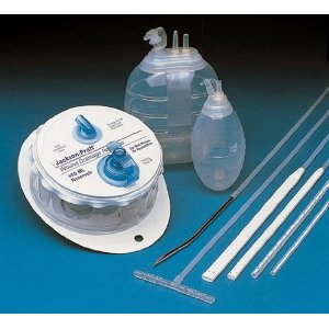 A Jackson-Pratt closed-suction drain. The nurse must compress the flexible bulb before replacing the plug to establish the negative suction pressure required to pull fluid from the wound.