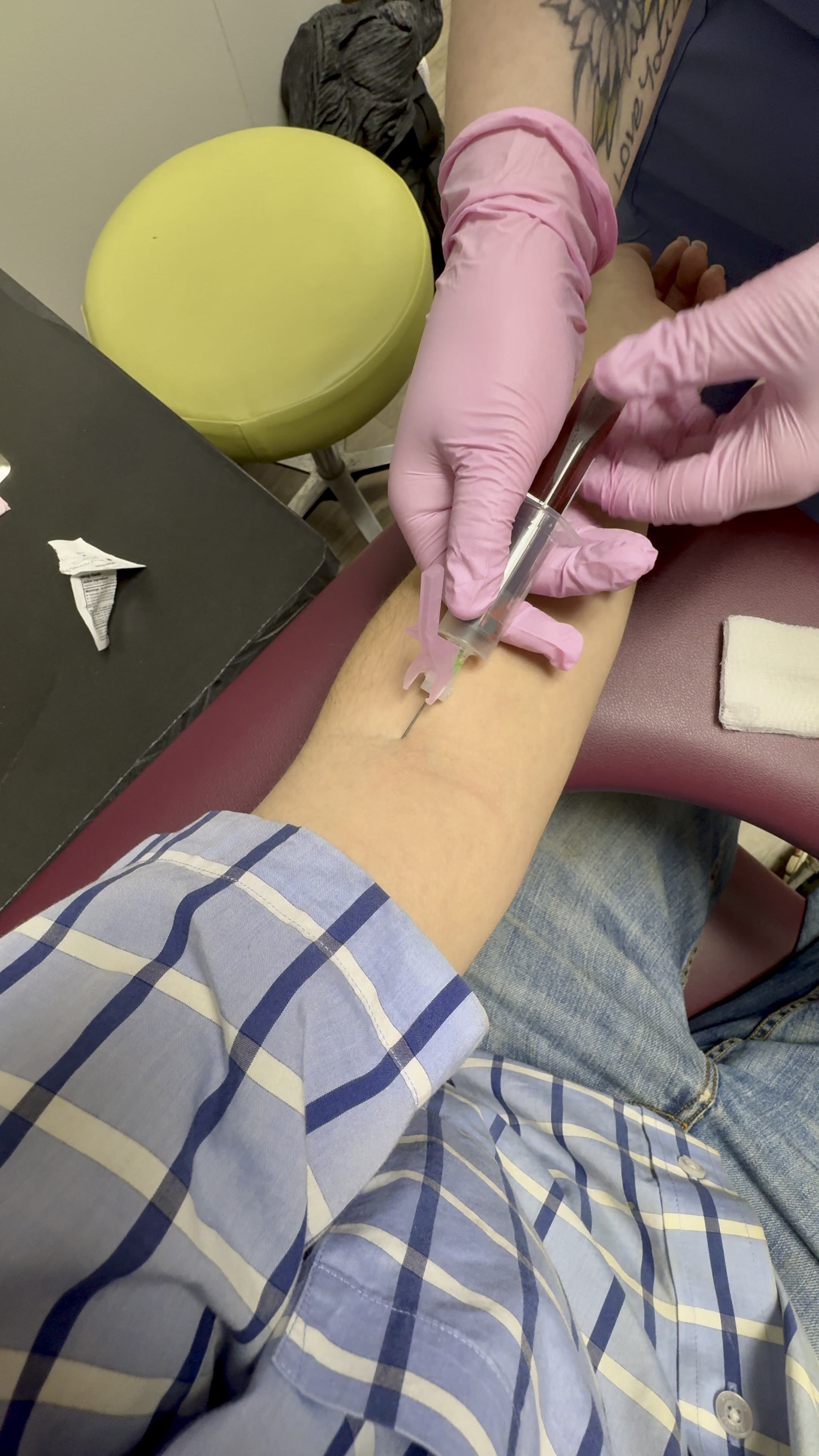 A phlebotomist drawing blood. Even if state laws permit an LPN to perform venipuncture, hospital-specific policies can restrict delegation limits further.