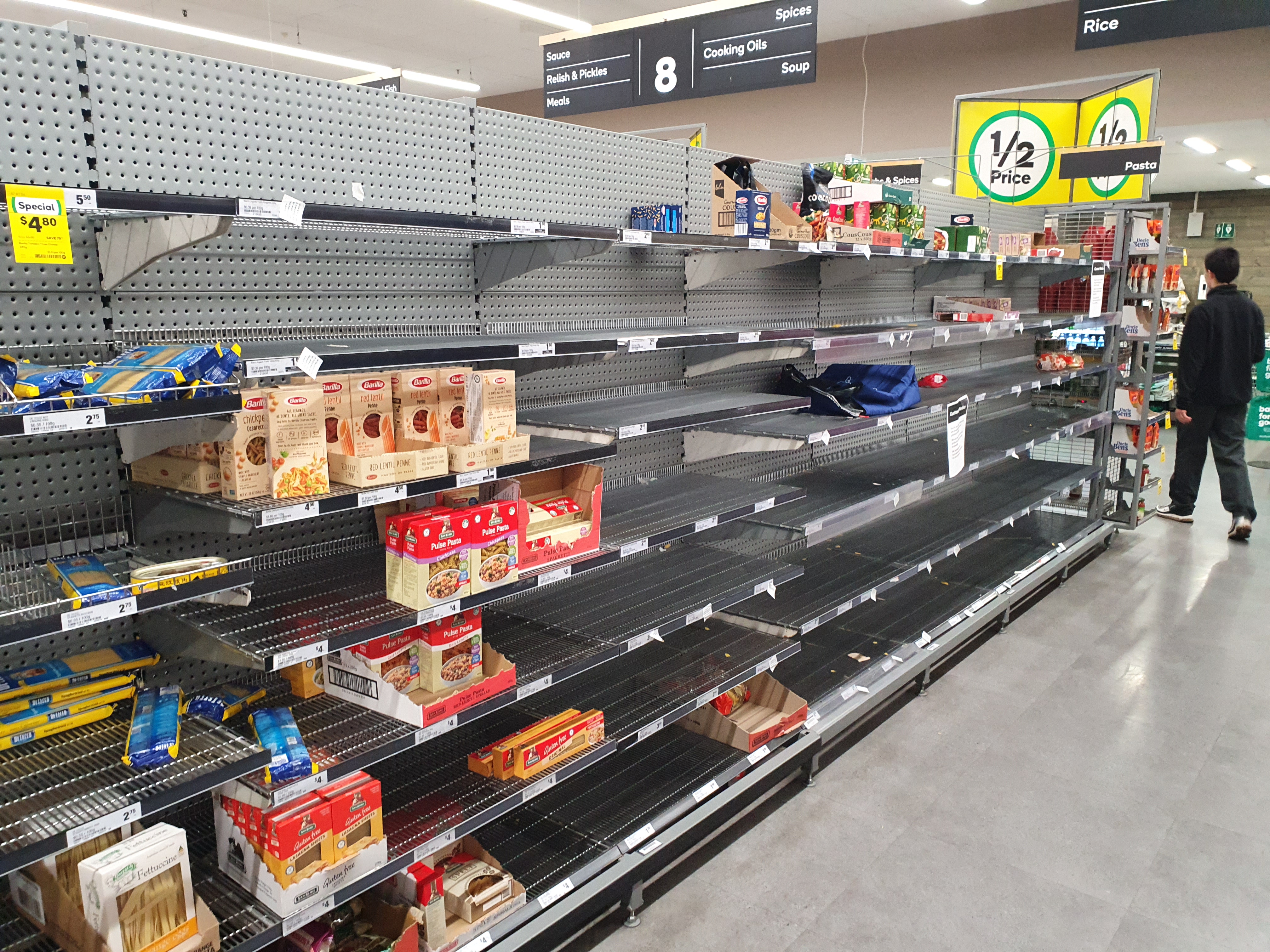 Empty supermarket shelves visually demonstrate an economic shortage, a state of disequilibrium where consumer demand temporarily exceeds the available producer supply.