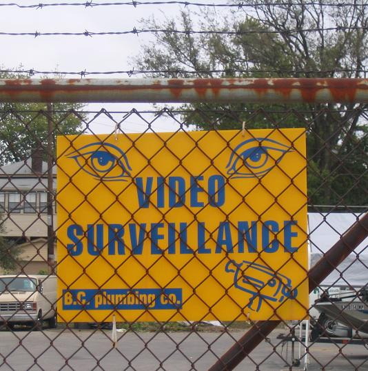 Warning signs act as a deterrent control by relying on the psychological threat of consequences—such as being recorded by CCTV—to discourage potential attackers from trespassing.