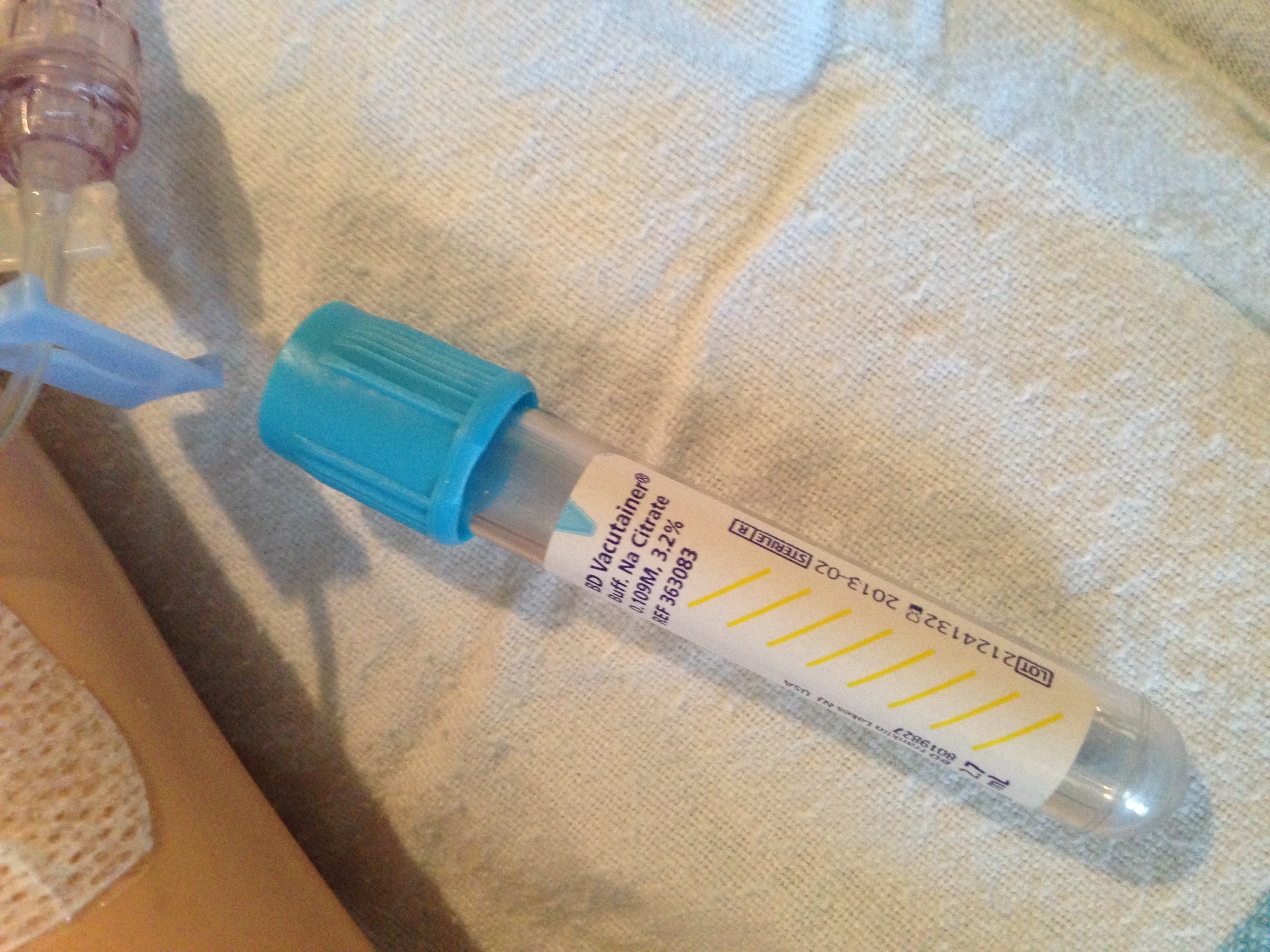 A blue-top vacutainer containing sodium citrate. These tubes must be filled entirely to the fill line to guarantee the exact blood-to-anticoagulant ratio required for accurate coagulation testing.