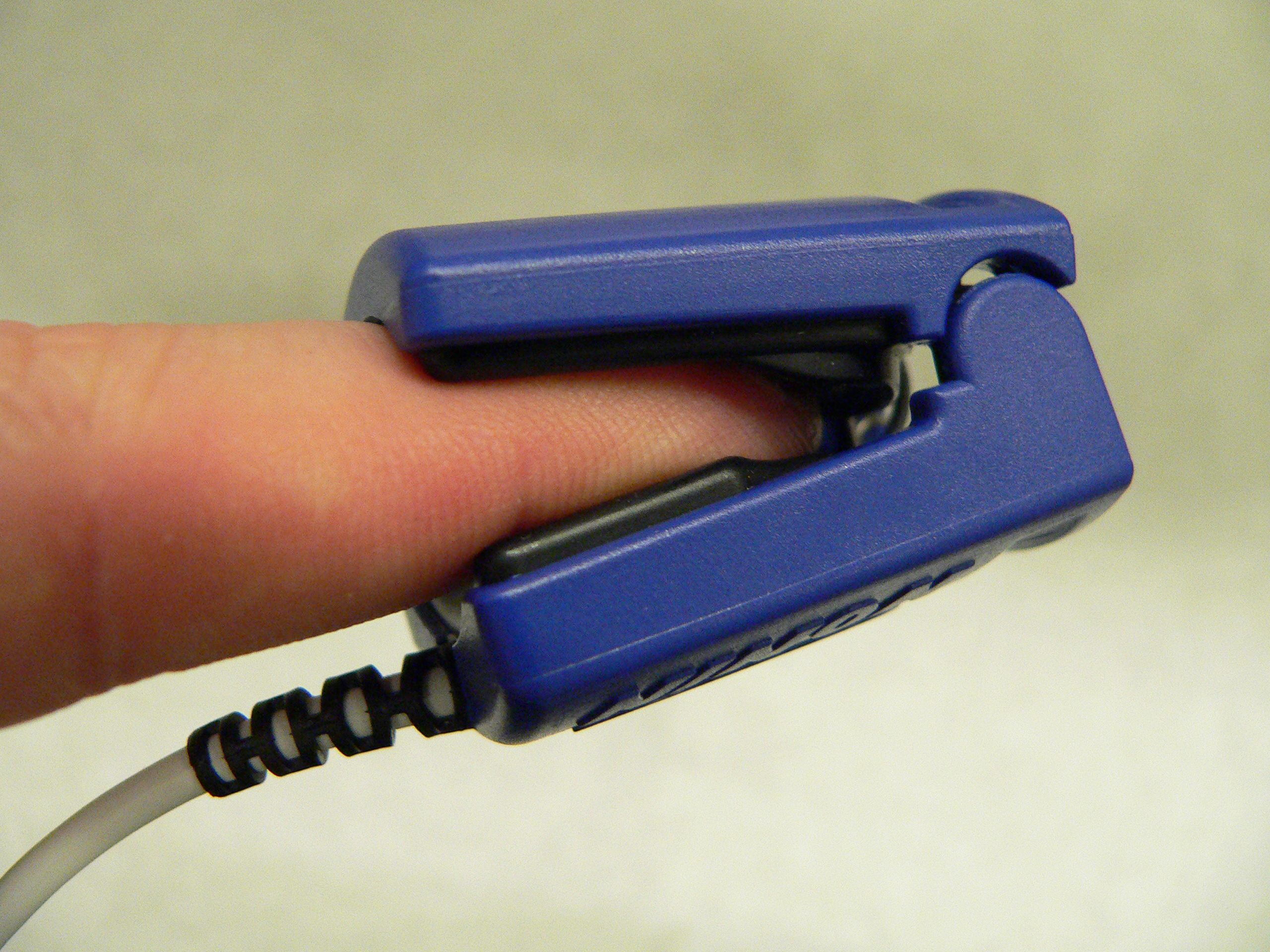 A continuous pulse oximeter probe applied to a digit, which is a mandatory safety measure for detecting respiratory depression in pediatric patients receiving opioids.