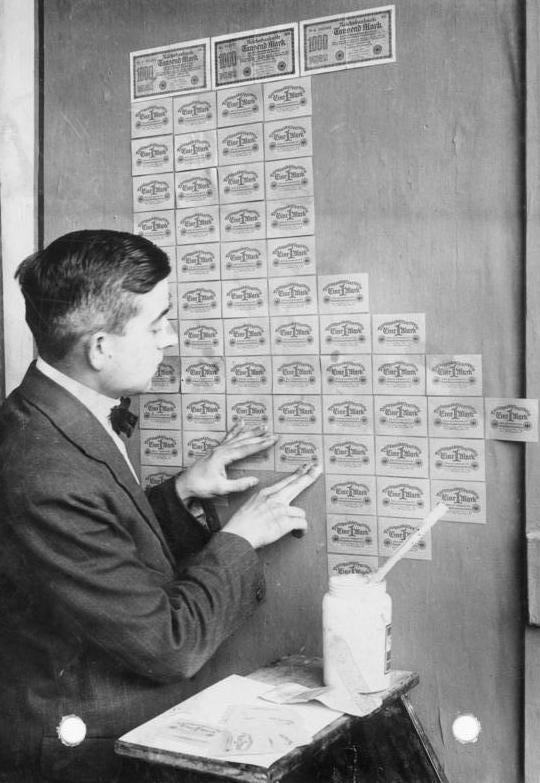 During periods of severe hyperinflation, a national currency loses its purchasing power so rapidly that paper money may become functionally worthless, as seen here with citizens using banknotes as wallpaper in 1923 Germany.