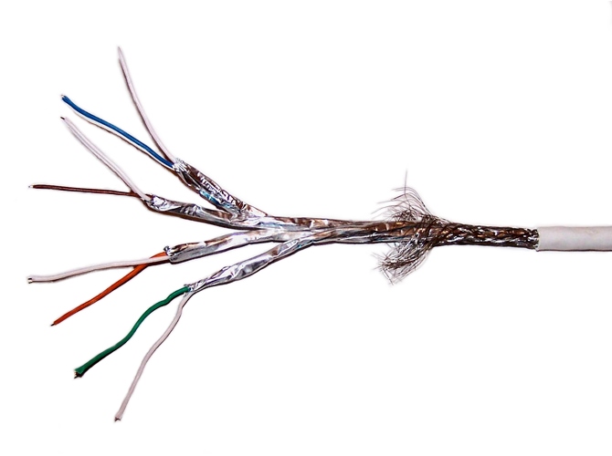 Shielded Twisted Pair (STP) cables incorporate an outer metallic foil layer to protect internal data signals from ambient electromagnetic interference in high-noise environments.