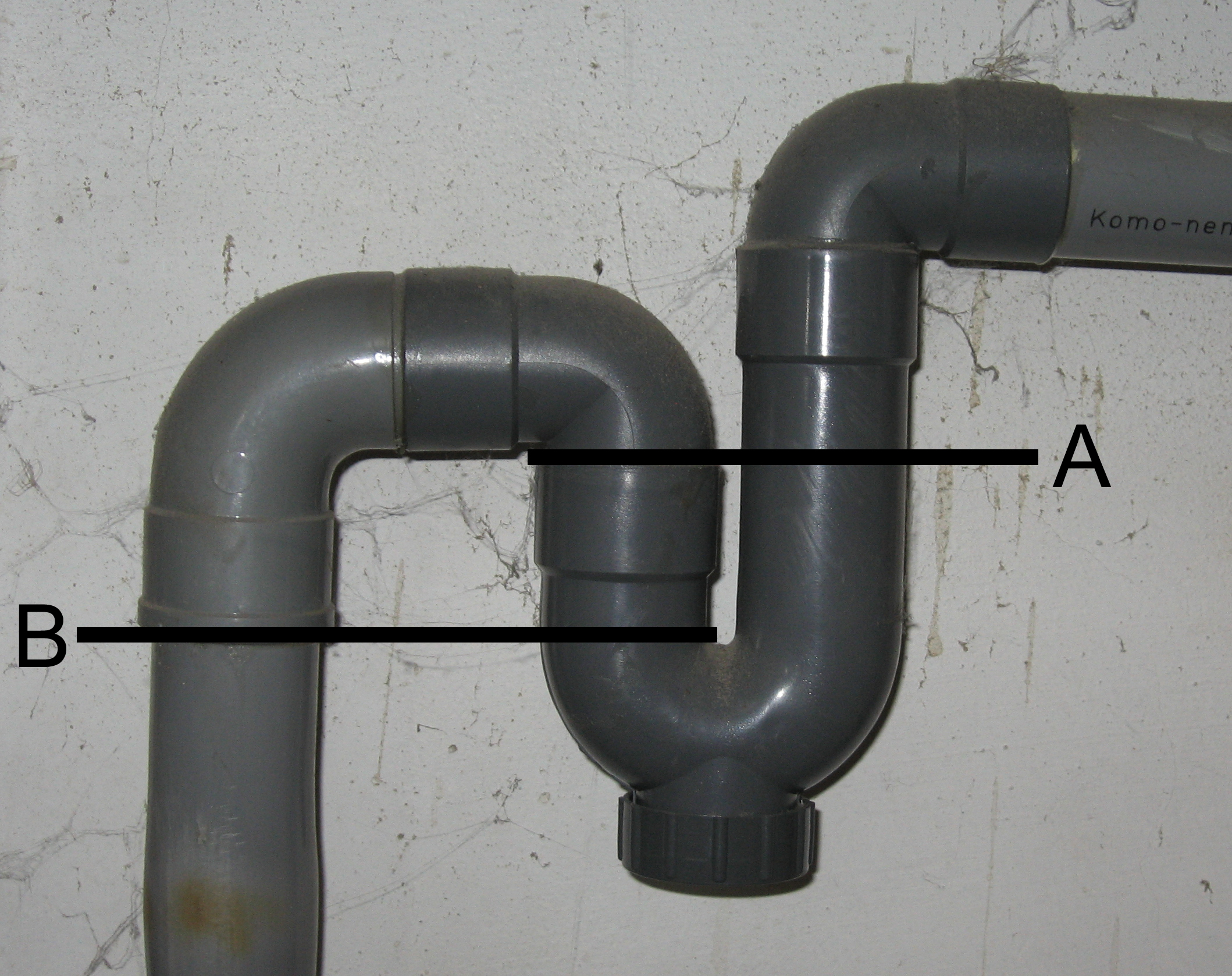 A cross-section of a plumbing trap demonstrating how the U-shaped curve retains a physical water seal to block toxic sewer gases from flowing backward into the residence.
