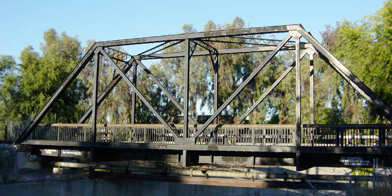 Structural engineering heavily relies on triangle congruence. Using CPCTC, engineers can calculate exact load-bearing lengths and structural angles within repetitive triangular units of a truss bridge.