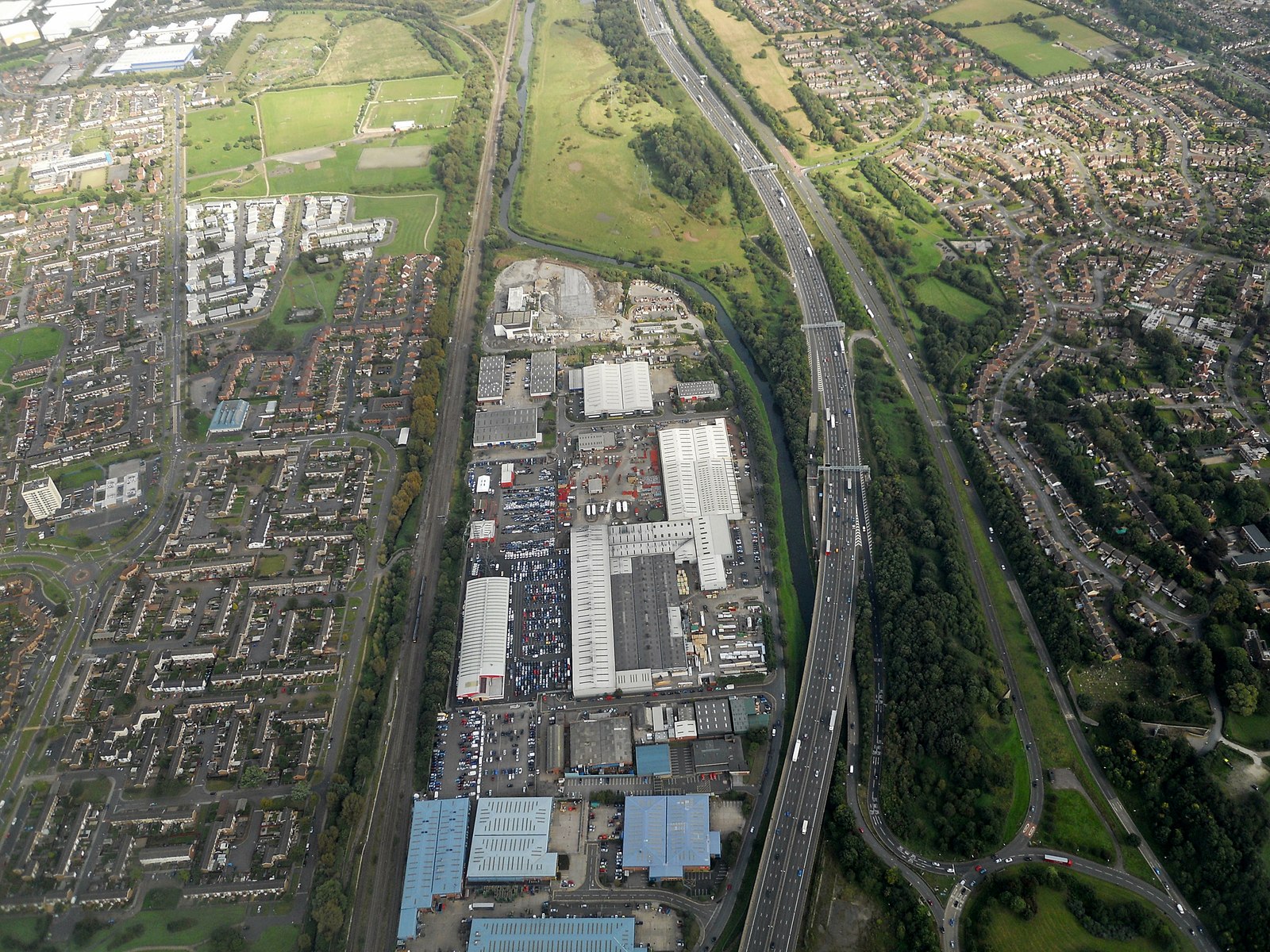 An aerial view showing the mix of residential, commercial, and open land uses that planning law exists to regulate — the starting point for asking whether any change here counts as 'development'.