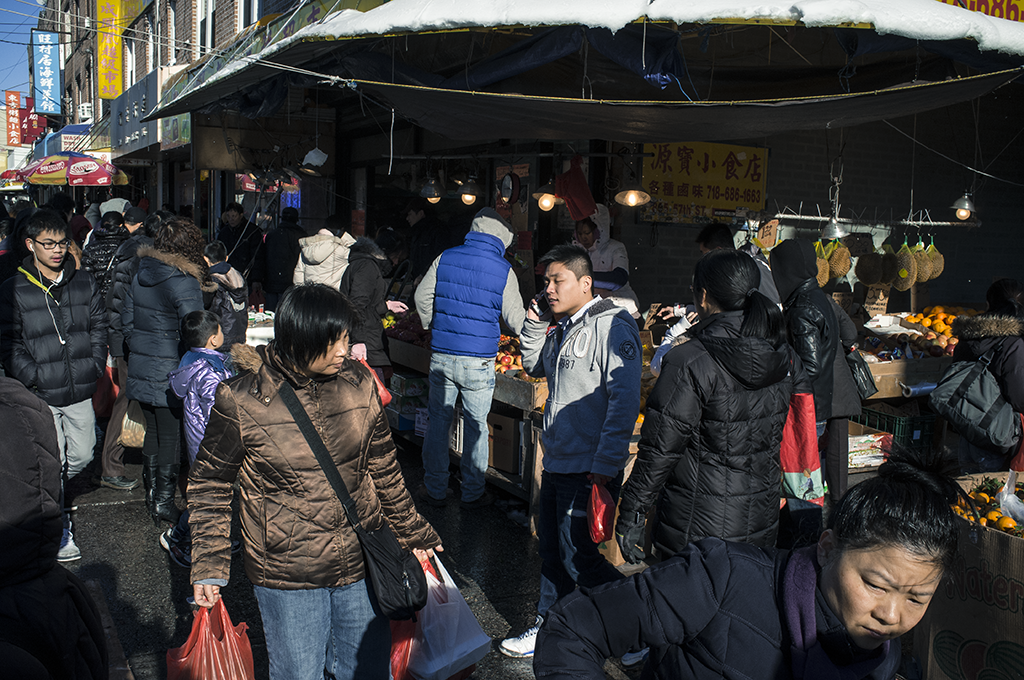 Ethnic enclaves, like this Chinatown in Brooklyn, New York, are vivid spatial manifestations of chain migration as individuals relocate to areas established by prior migrants of the same cultural group.