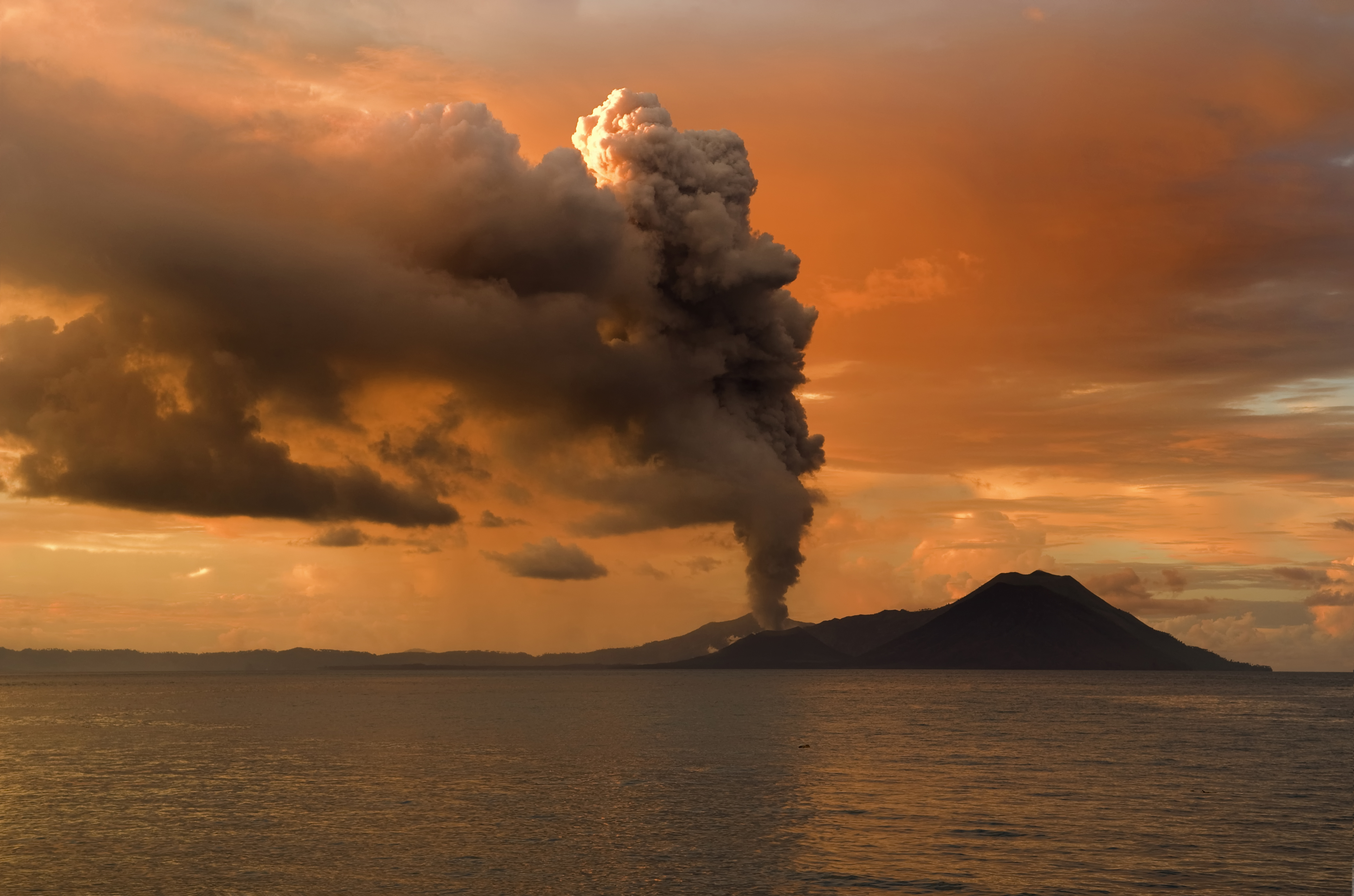 Volcanic eruptions, like this one at Tavurvur, demonstrate rapid geological change by violently ejecting ash and lava, which can reshape the surrounding landscape in mere hours.