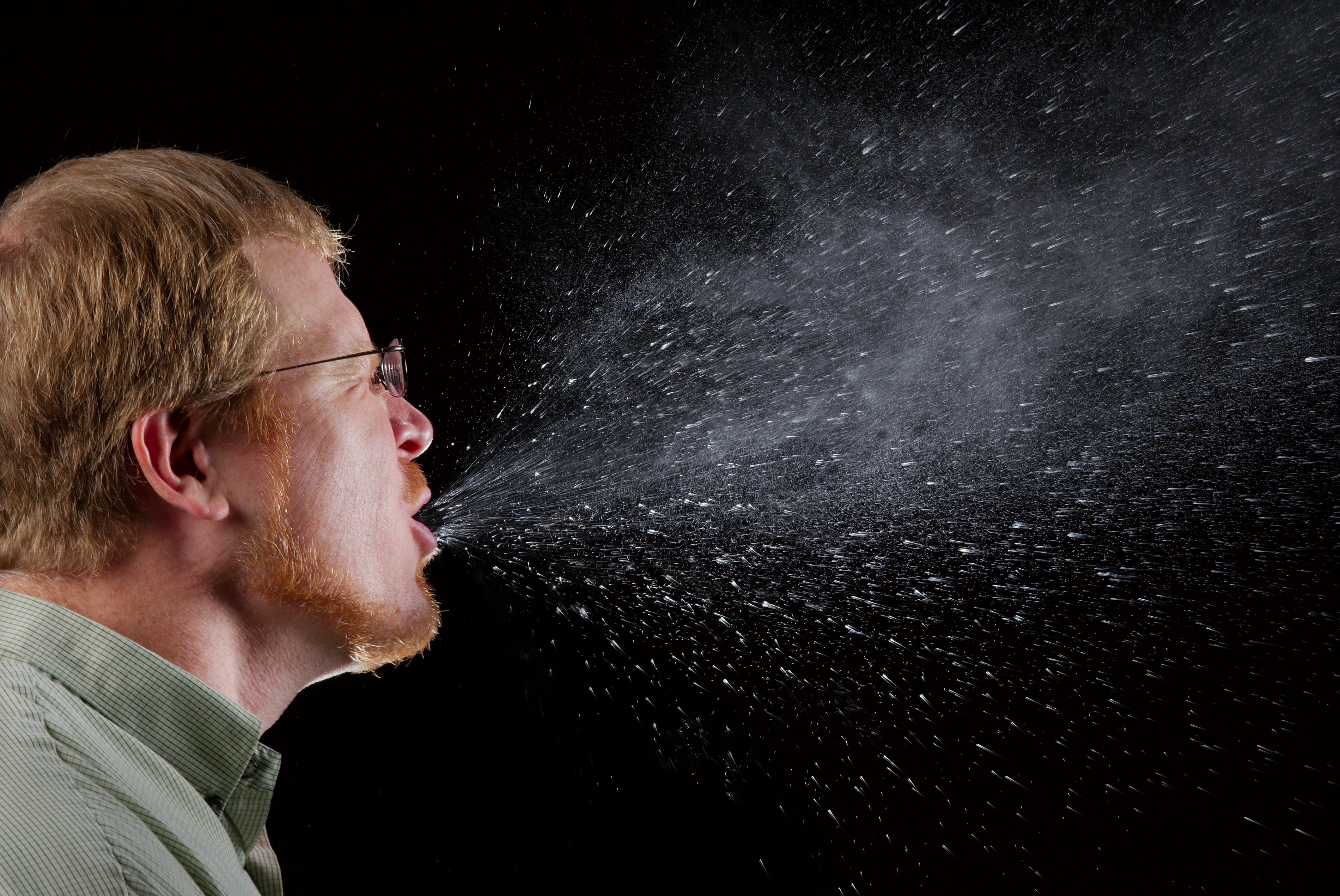Unlike aerosolized airborne particles, respiratory droplets expelled during a sneeze are relatively heavy. Gravity quickly pulls them to the ground, strictly limiting their infection radius to a few feet.