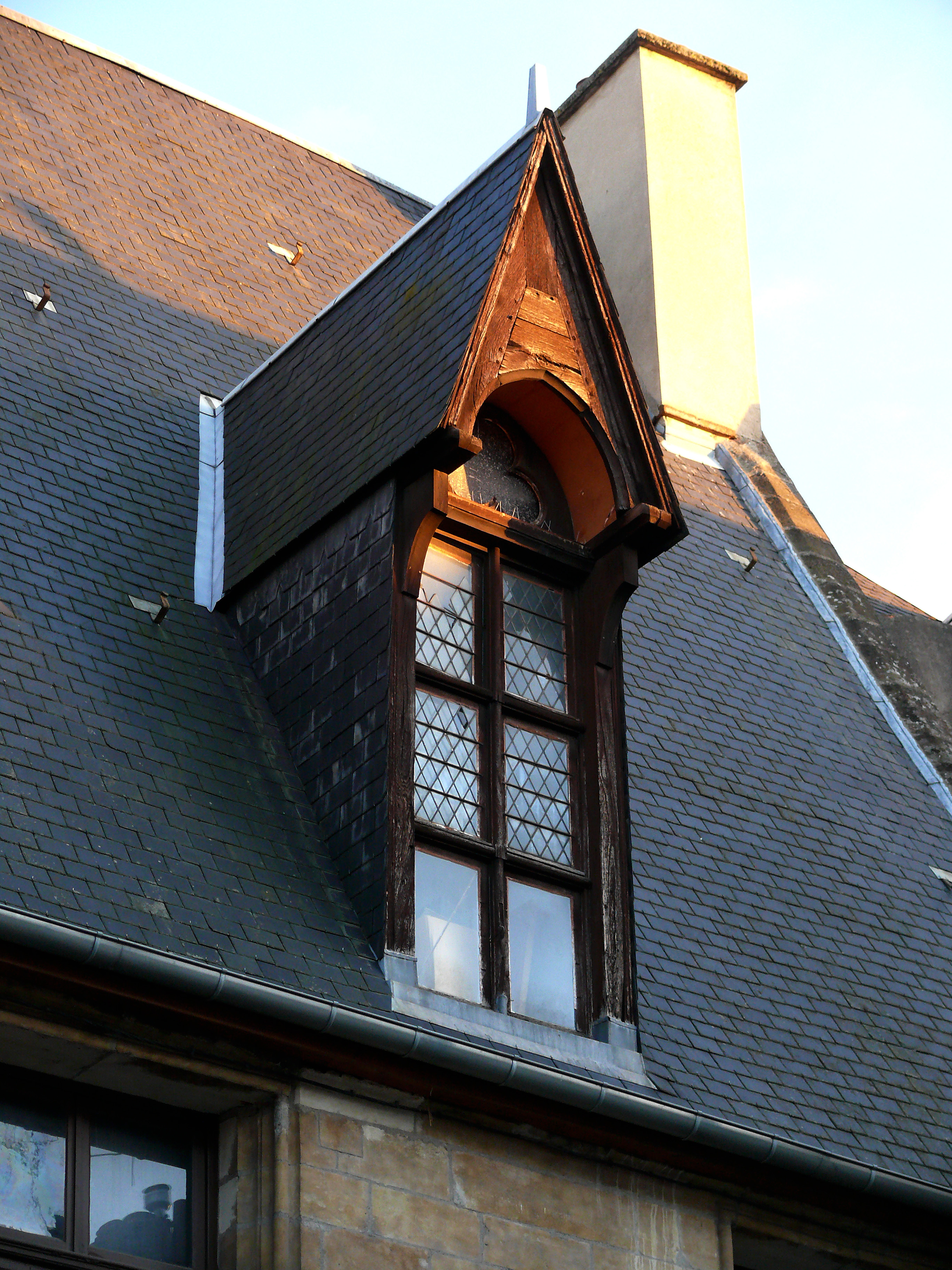 Metal flashing installed at the intersection of a dormer and the primary roofline to prevent water penetration into the structure's joints.