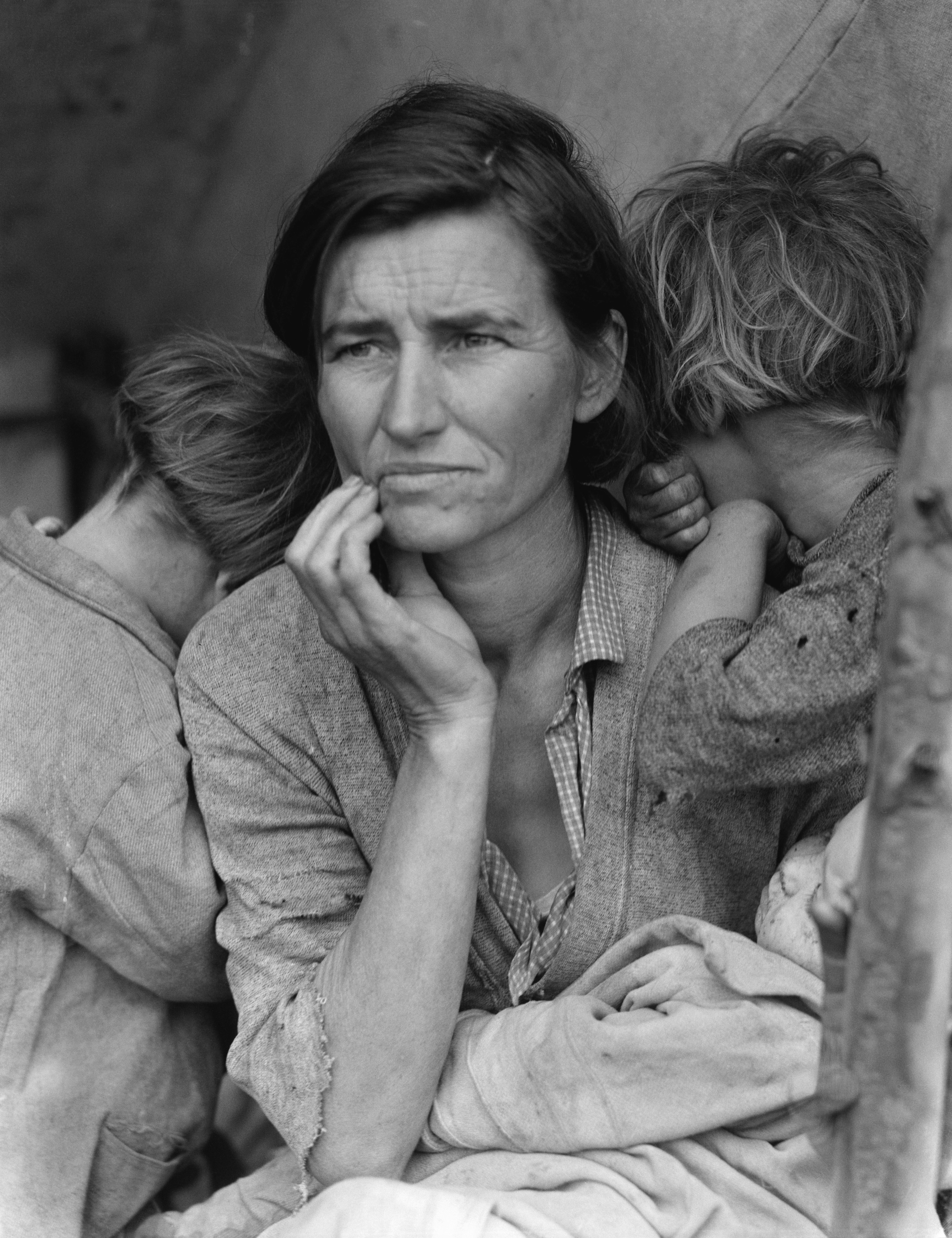 Dorothea Lange's iconic 1936 photograph "Migrant Mother" captures the devastating reality of the Great Depression that John Steinbeck documented in his social realism novels.