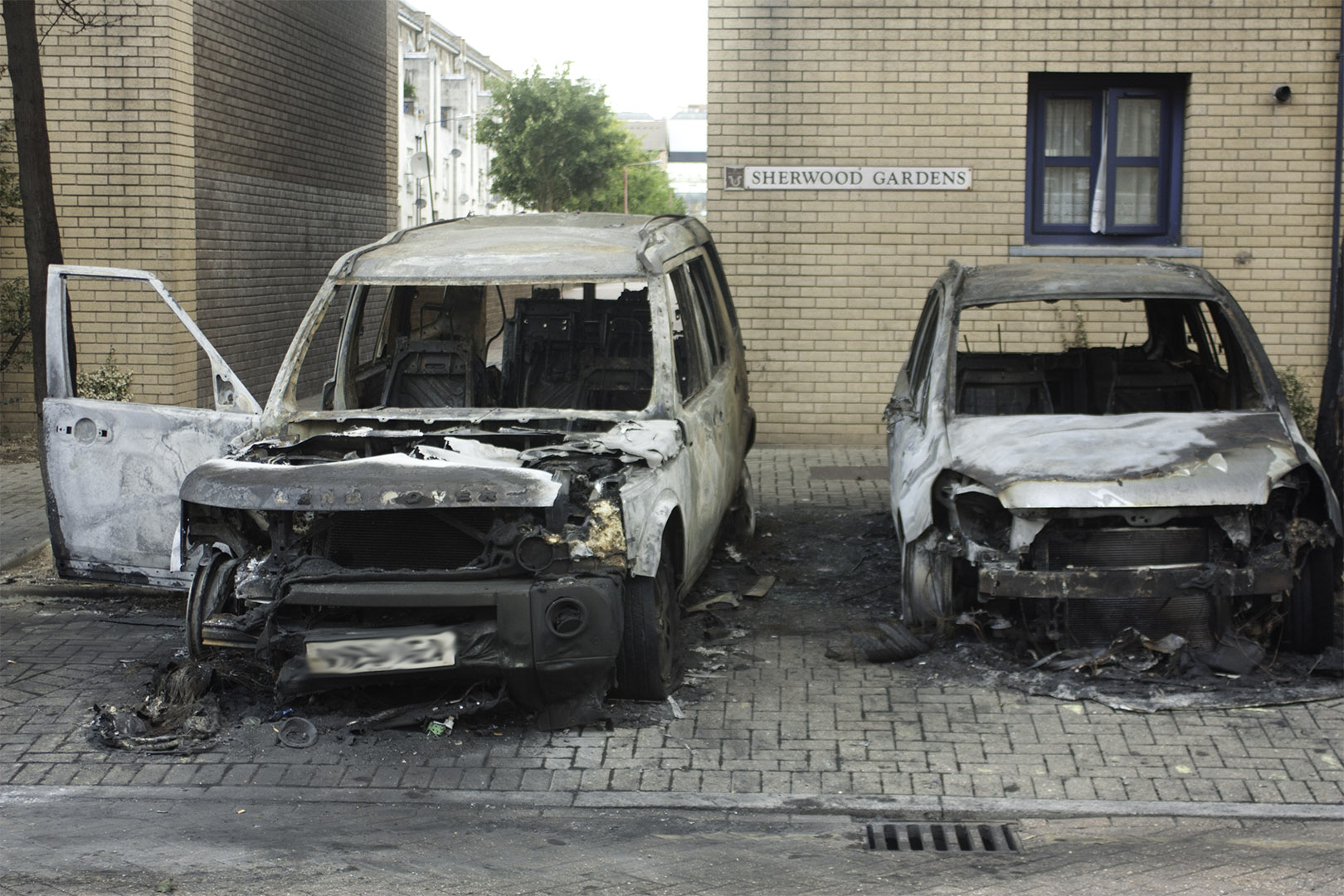 Burnt-out cars after arson during the 2011 England riots — criminal damage caused by fire has no value ceiling and remains an either-way offence regardless of how much damage is done.