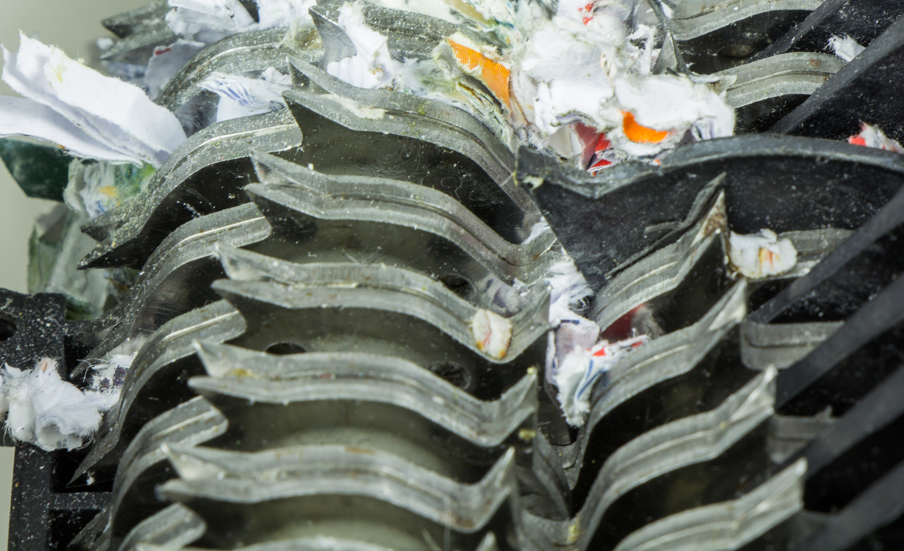 A cross-cut paper shredder destroying physical documents. Meticulous data disposal mechanisms are legally required to prevent the unauthorized reconstruction of sensitive client information.
