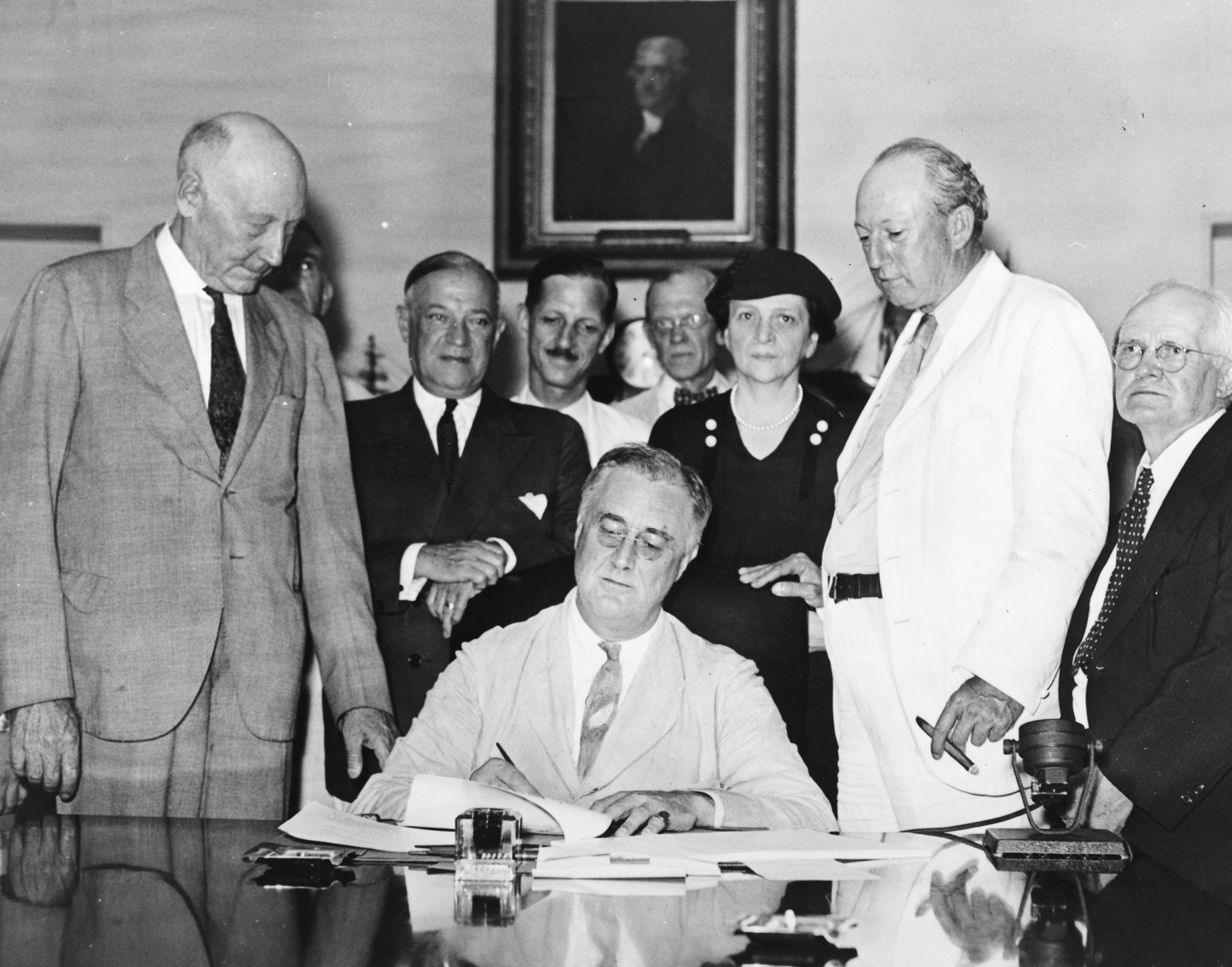 President Franklin D. Roosevelt signs the Social Security Act in 1935, permanently altering the American social contract by establishing a federal safety net for the elderly, unemployed, and handicapped.