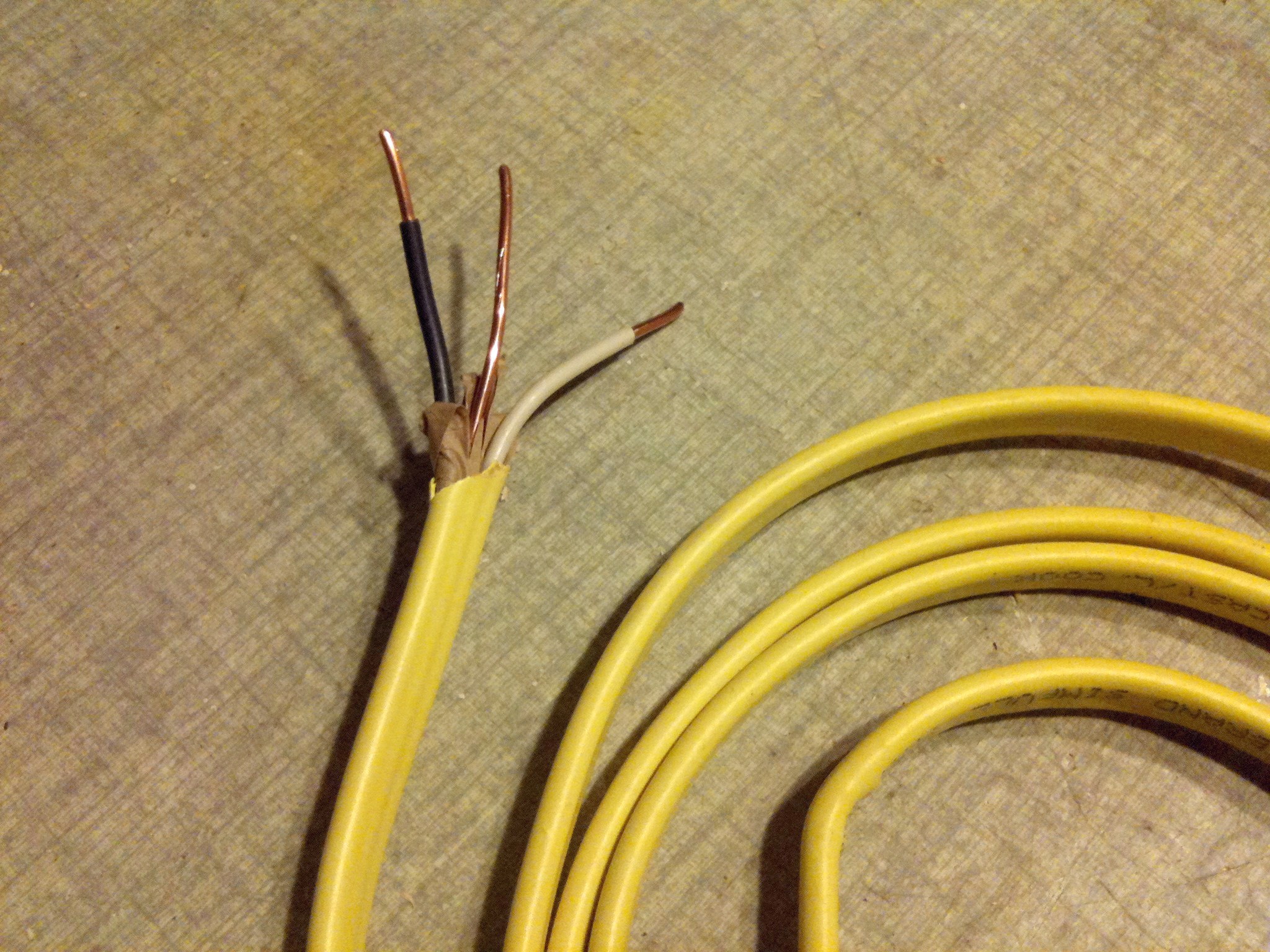Non-metallic sheathed cable, commonly referred to by the brand name Romex, features multiple wires wrapped inside a flexible plastic jacket. It is the standard for modern residential wall interiors.