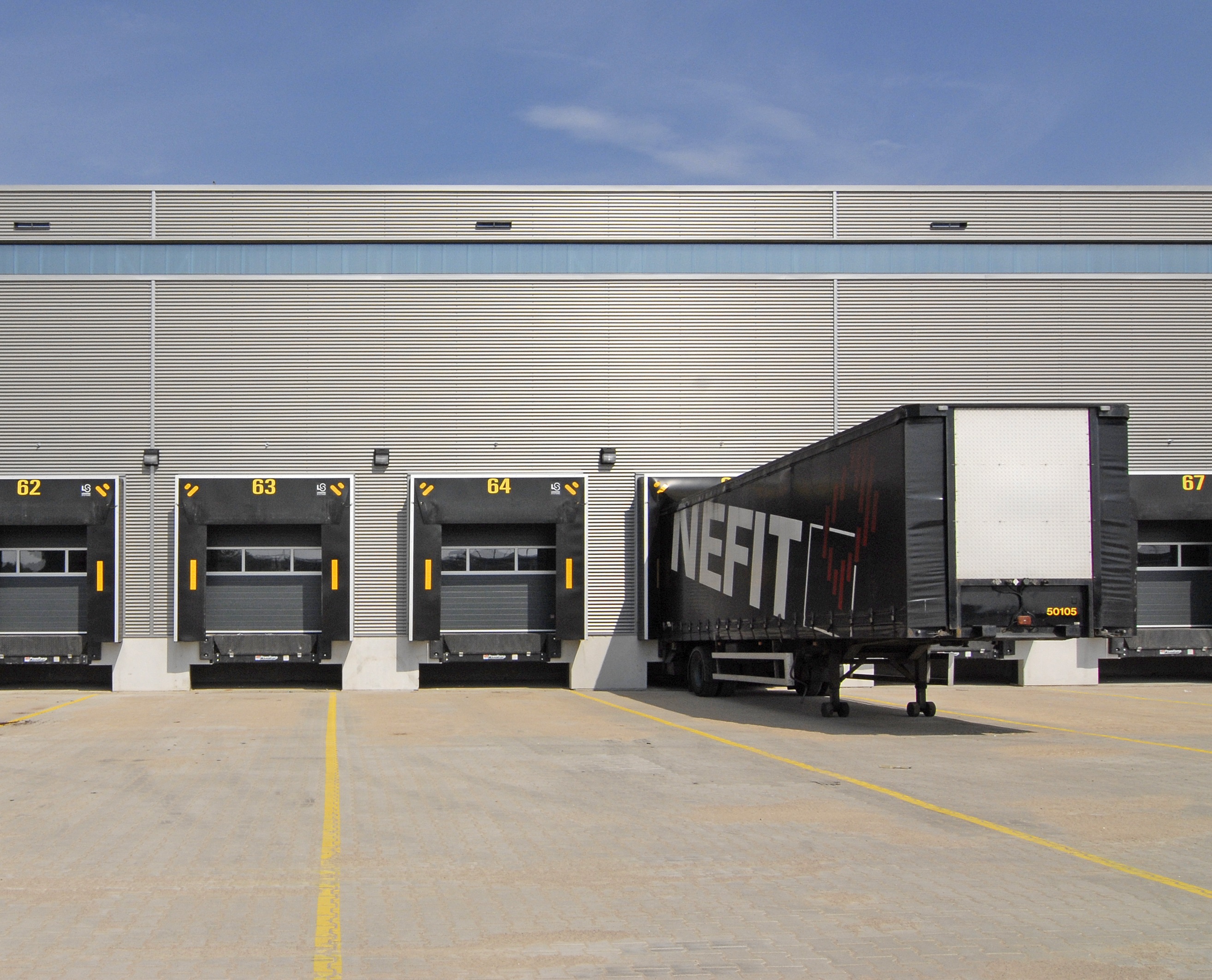 Distribution centers prioritize logistical efficiency, utilizing numerous loading docks for the rapid processing and movement of goods.